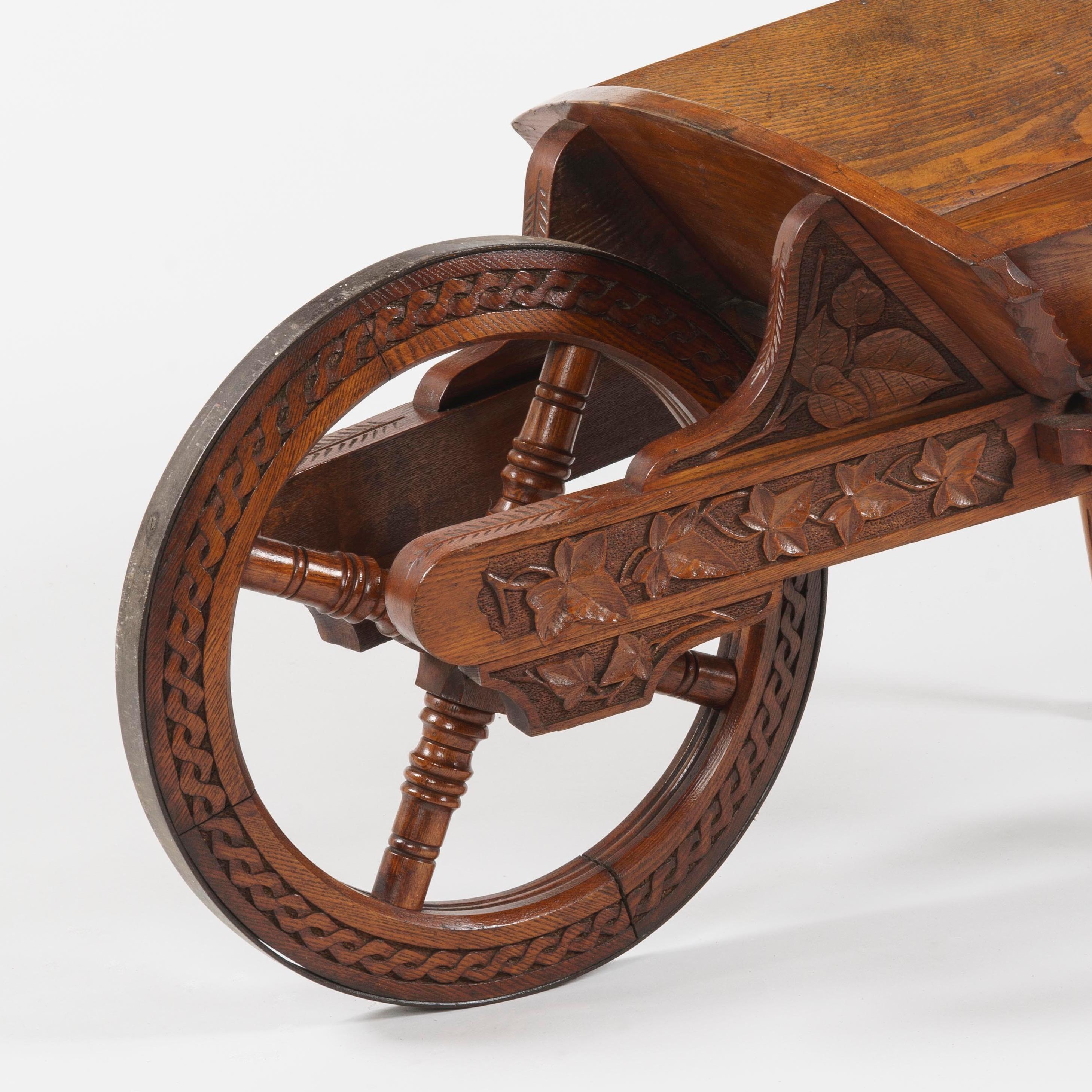 A late 19th century oak presentation wheelbarrow
Commemorating the Great Western Railway Extension

The presentation wheelbarrow carved from oak with finely carved ivy leaves and foliage adorning the frame, the front wheel with turned spokes and