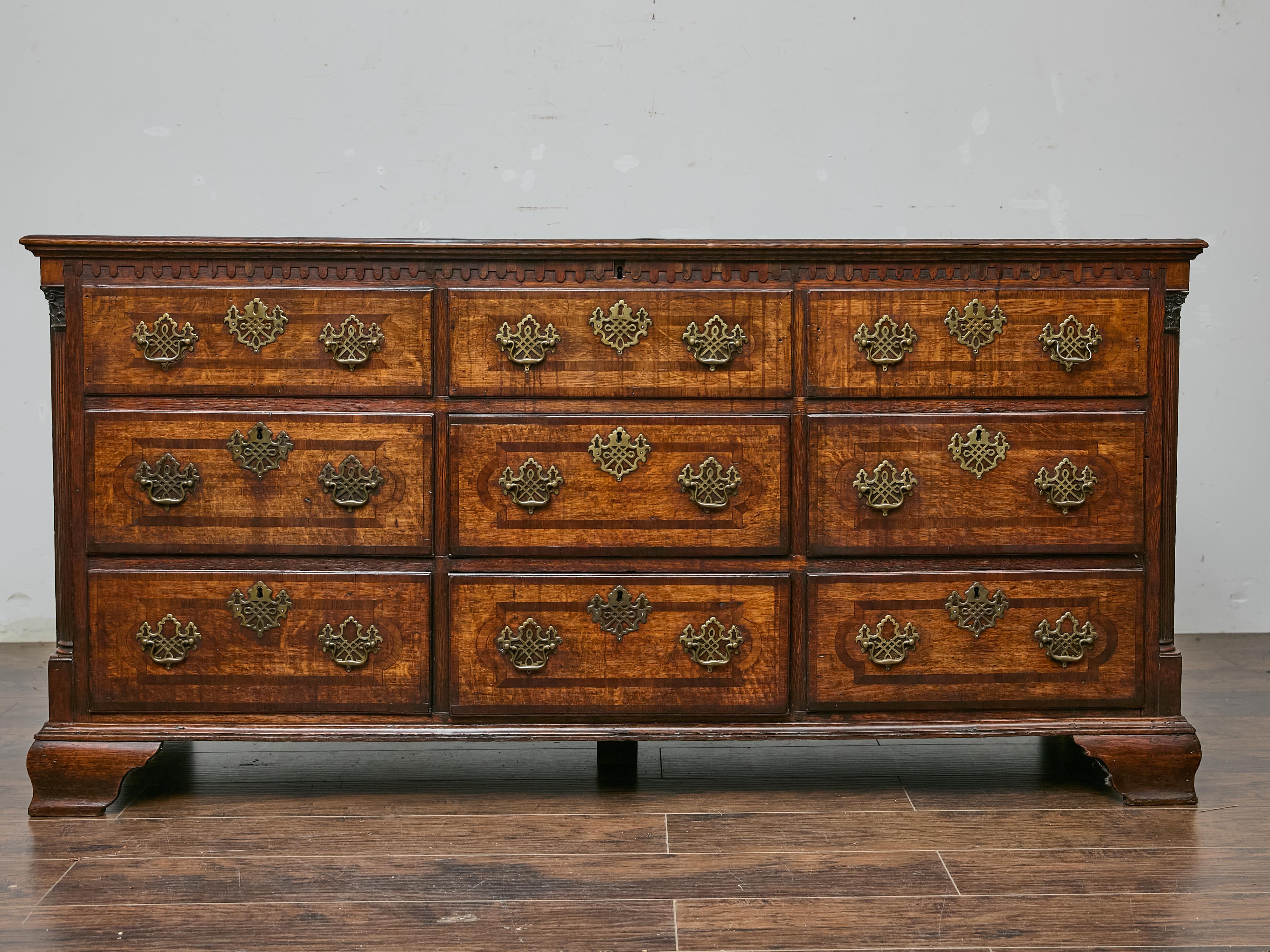 A 19th-century English oak mule chest, combining the practical storage of a trunk with the convenience of drawers, brings timeless character to any home. The rich oak patina, accented by brass hardware, showcases the warmth and depth of its