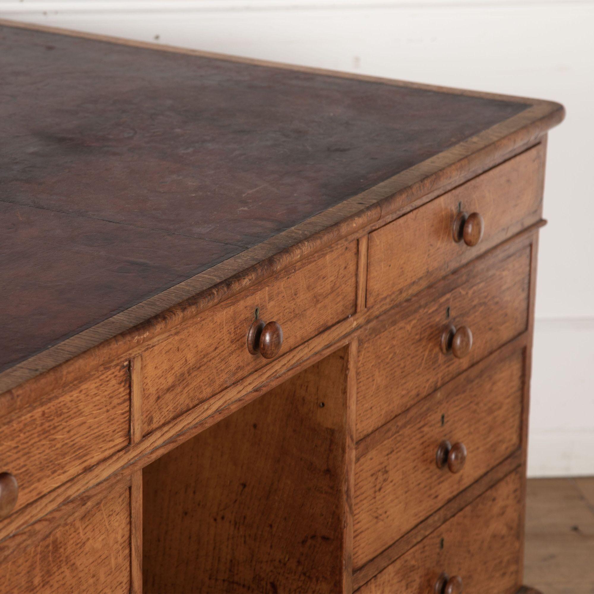 19th century oak partners desk with its original tooled red leather writing surface on top, surrounded by a cross banded border.
Three drawers in the frieze on one side, with a bank of three drawers below, having pull handles.
The pedestals on the