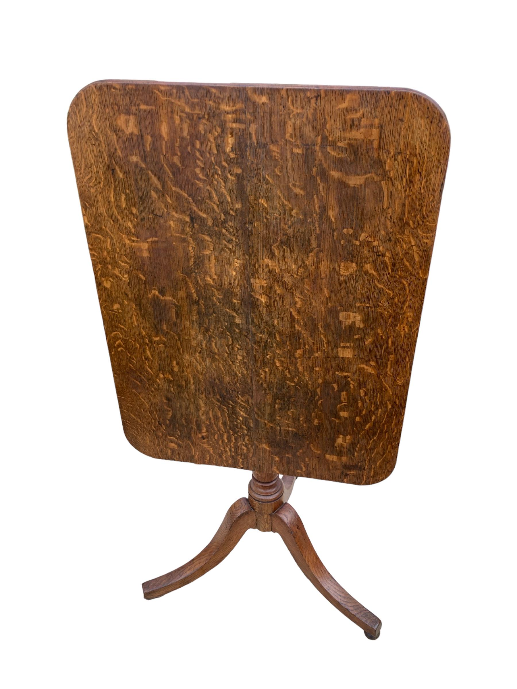 An Original 19th Century English Oak Rectangular Tri Legged Tilt top table. Beautifully crafted wooden top, adding a touch of elegance to any room. The intricate details and sturdy construction make it a timeless piece that will last for generations