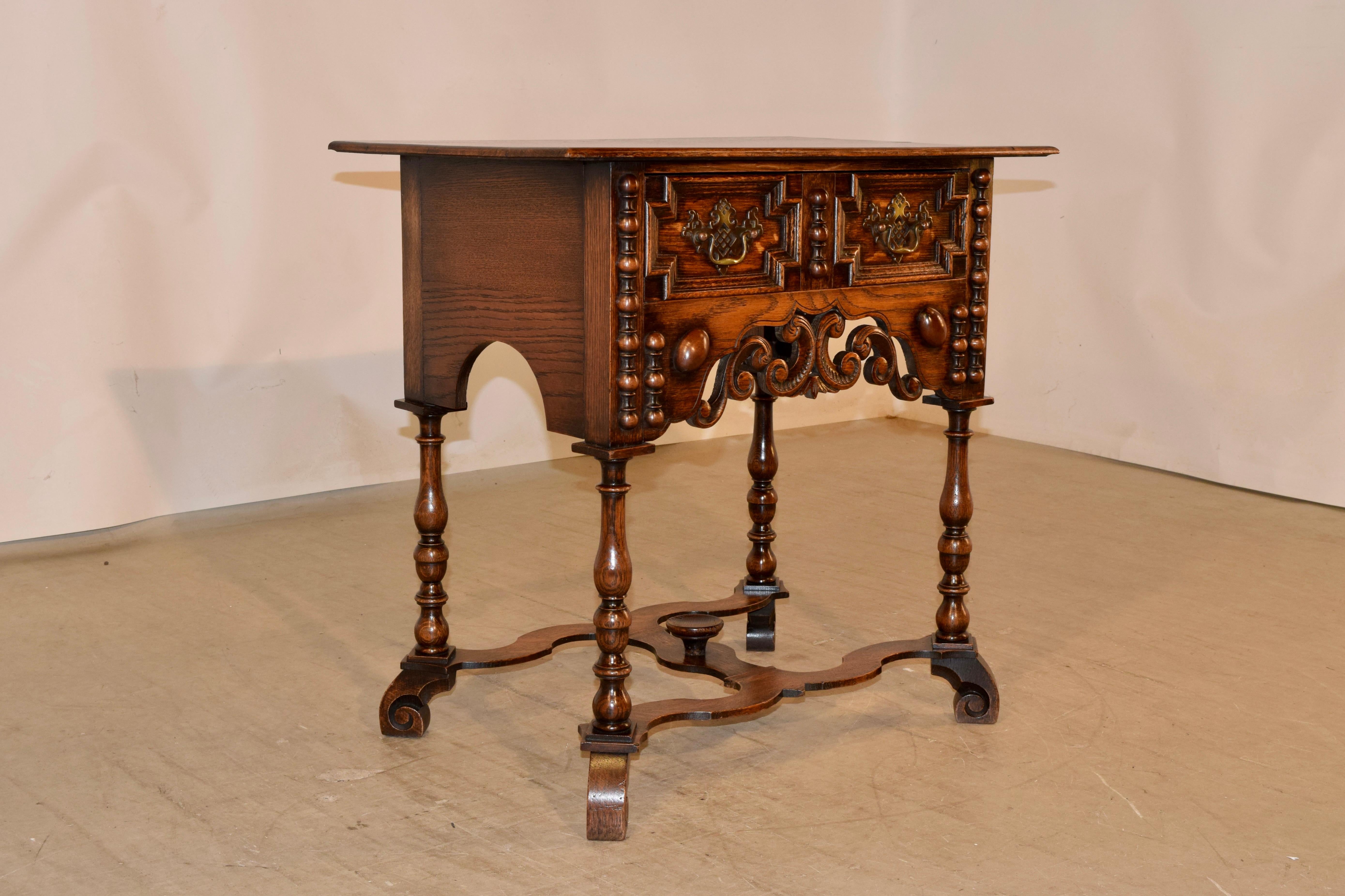 19th Century oak side table from England in a William & Mary style. The top is made from two boards, following down to simple sides with scalloping and a single drawer in the front with geometric paneled detailing over a scalloped and pierced apron.