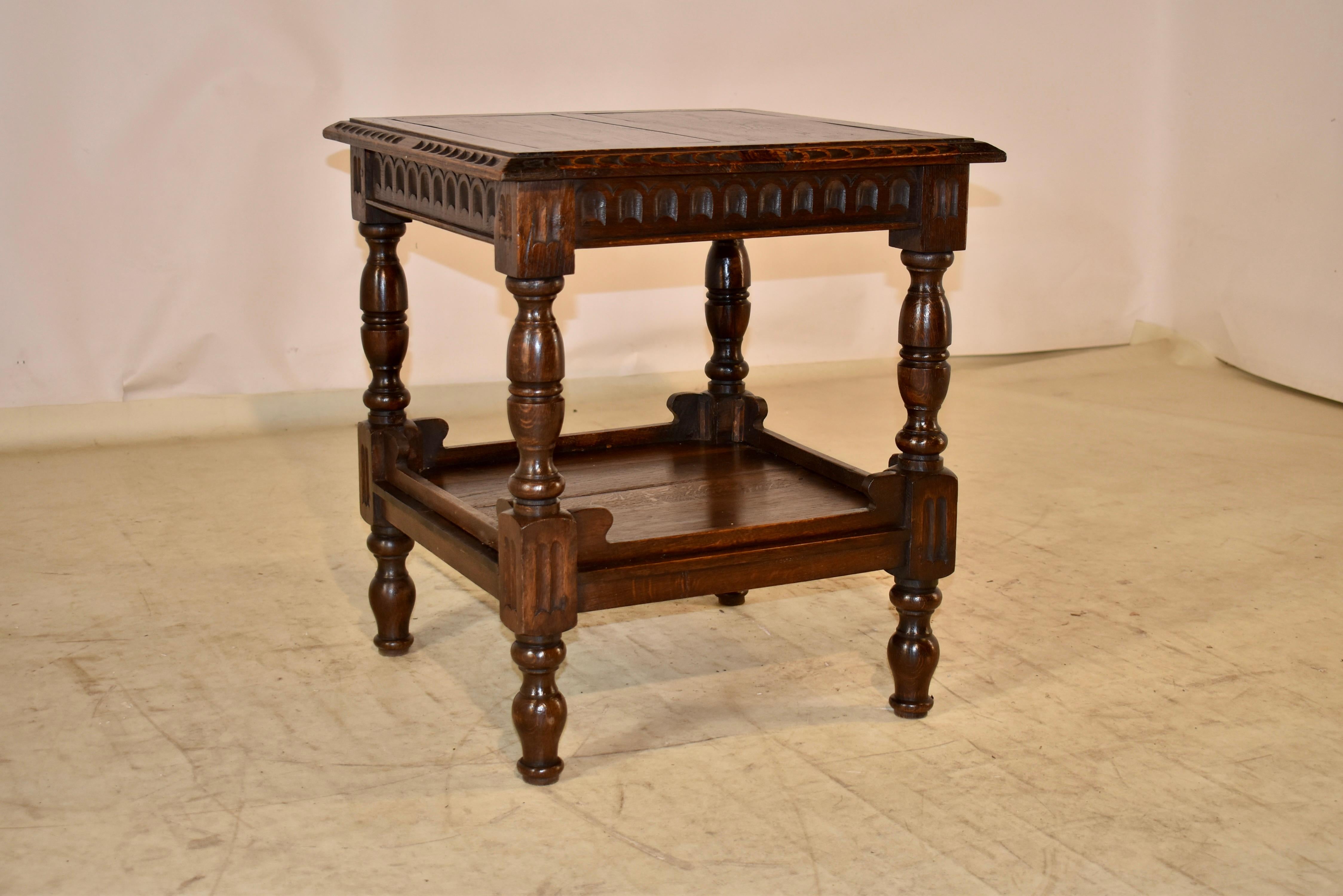 19th century oak side table from England with a paneled top, which features carved and beveled edges, following down to a hand carved apron in a nulled pattern. The table is supported on hand turned legs which are joined by a lower shelf. the lower