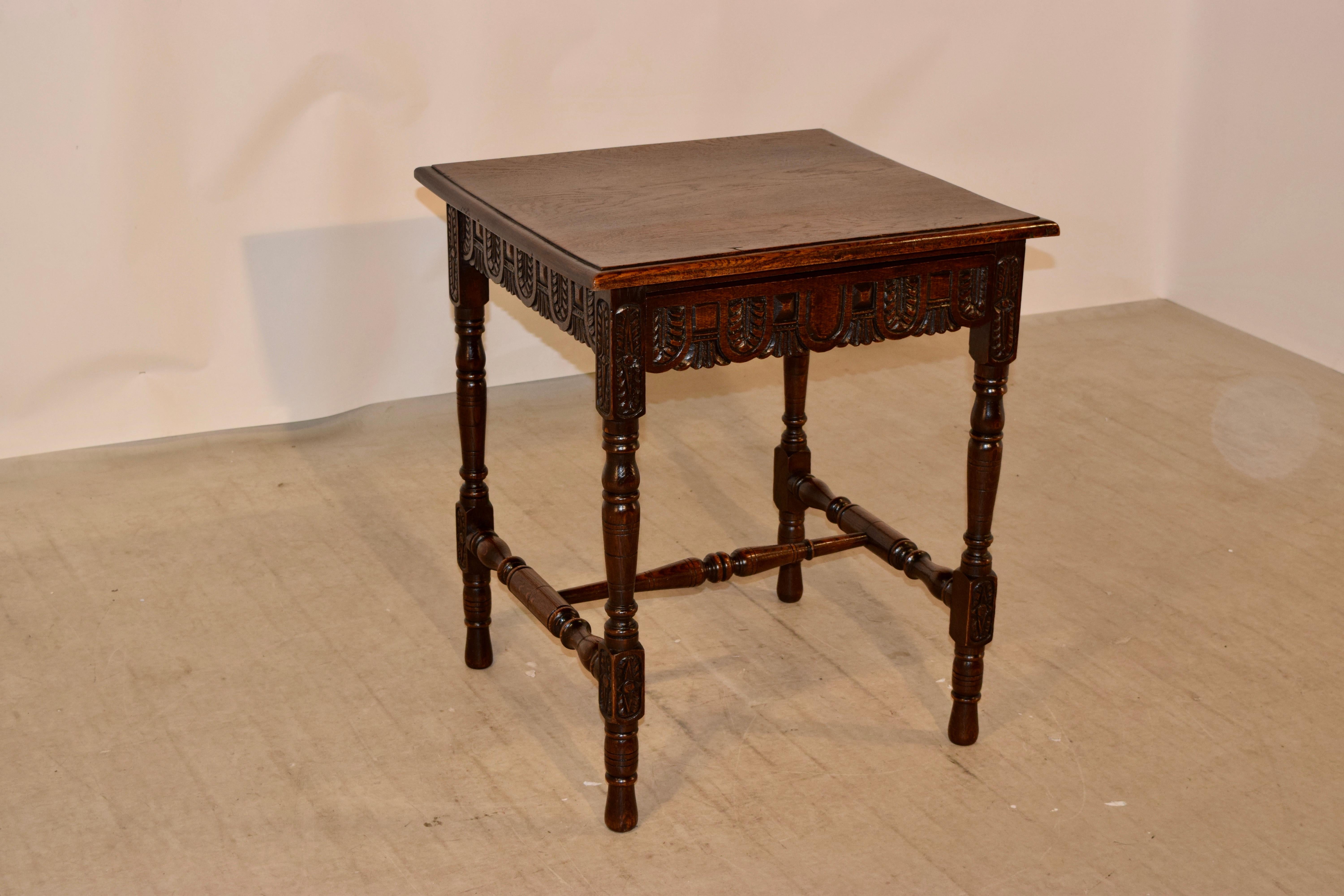 19th century English oak side table with a beveled edge around the top, following down to a hand carved decorated apron which contains a single drawer in the front. The table is supported on hand turned legs, joined by matching stretchers. Raised on