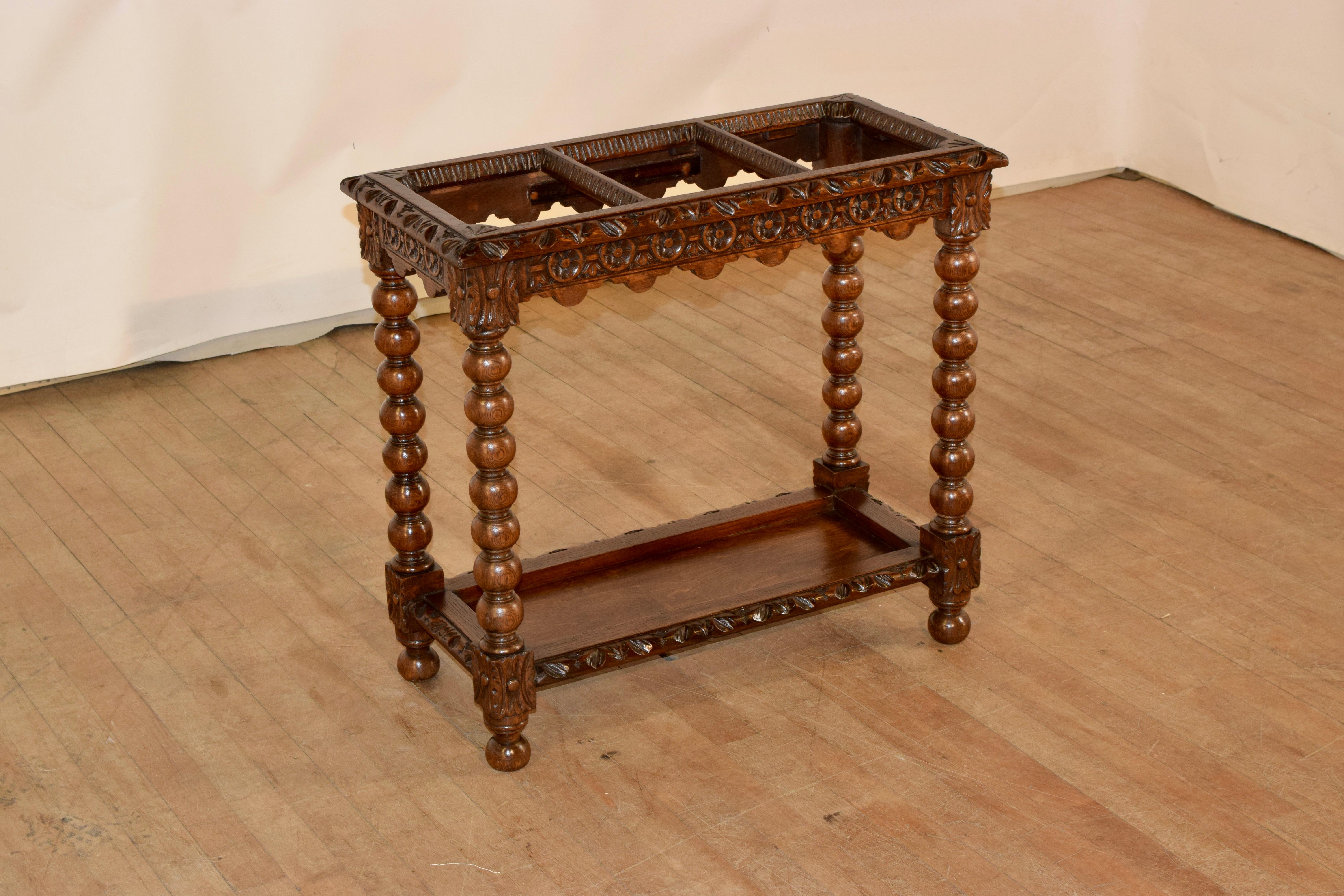 Extraordinary 19th century stick stand from England made from oak. The top has beveled and hand carved decoration around the edges, and has three separated sections for storing walking sticks or umbrellas. the apron is also exquisitely hand carved