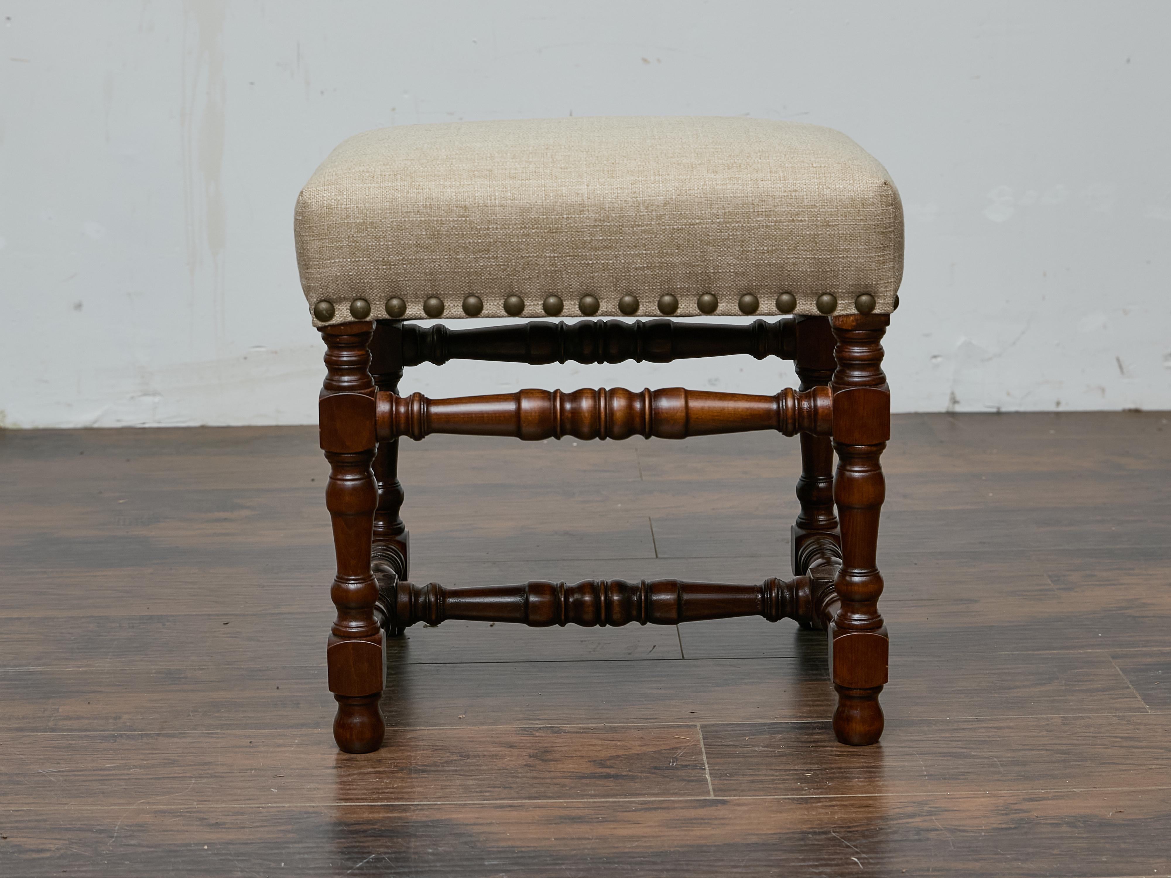 Questo sgabello in quercia inglese del XIX secolo è caratterizzato da una seduta rivestita in lino su misura e incorniciata da una serie di decorazioni in ottone antico. Le sue gambe e le sue barelle tornite mettono in mostra le tecniche