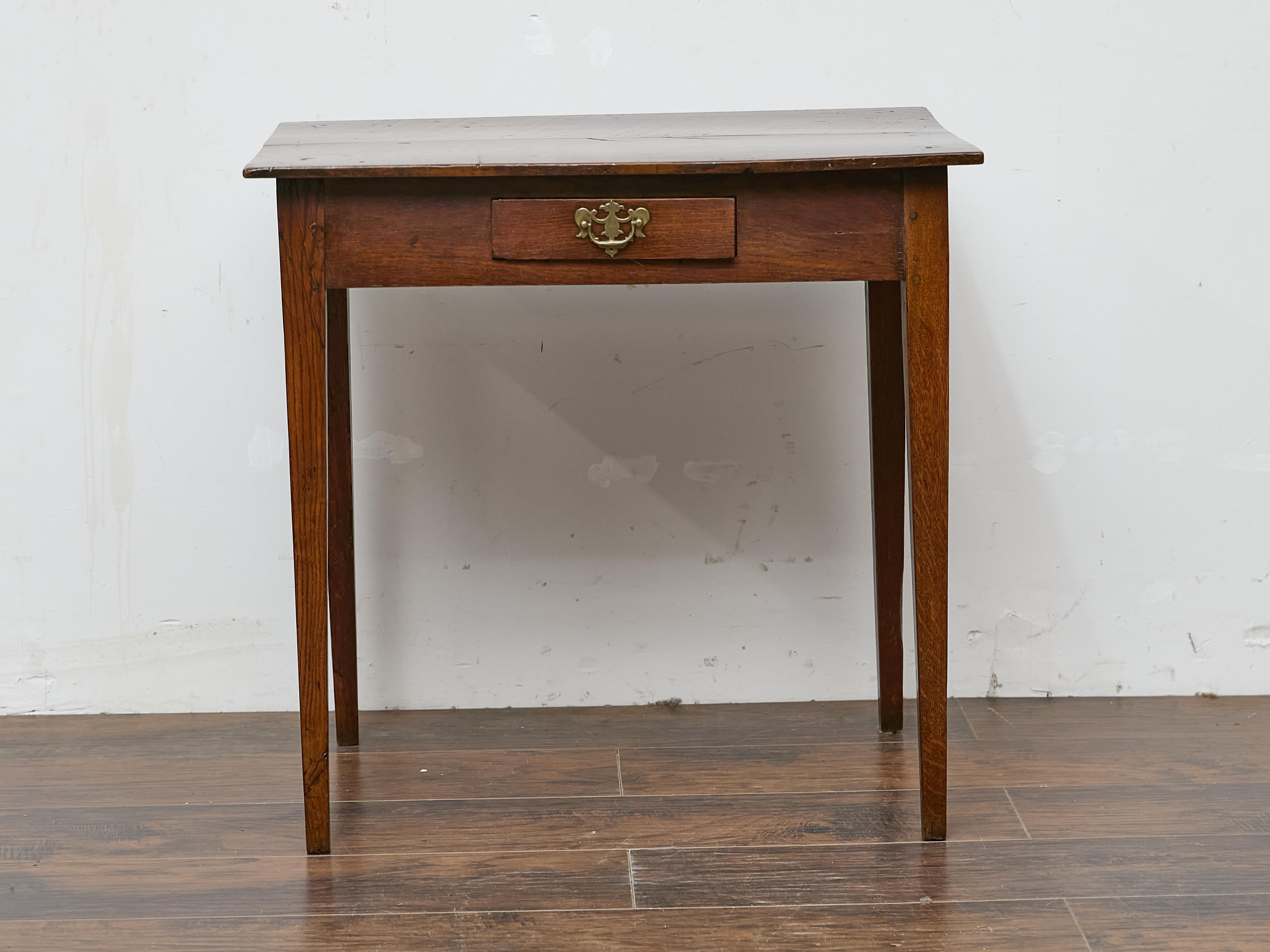 Cette table d'appoint en chêne anglais du XIXe siècle affiche une élégance intemporelle avec ses lignes épurées et son understated design. Le grain profond du chêne est accentué par une patine riche et usée par le temps, tandis qu'un tiroir unique,