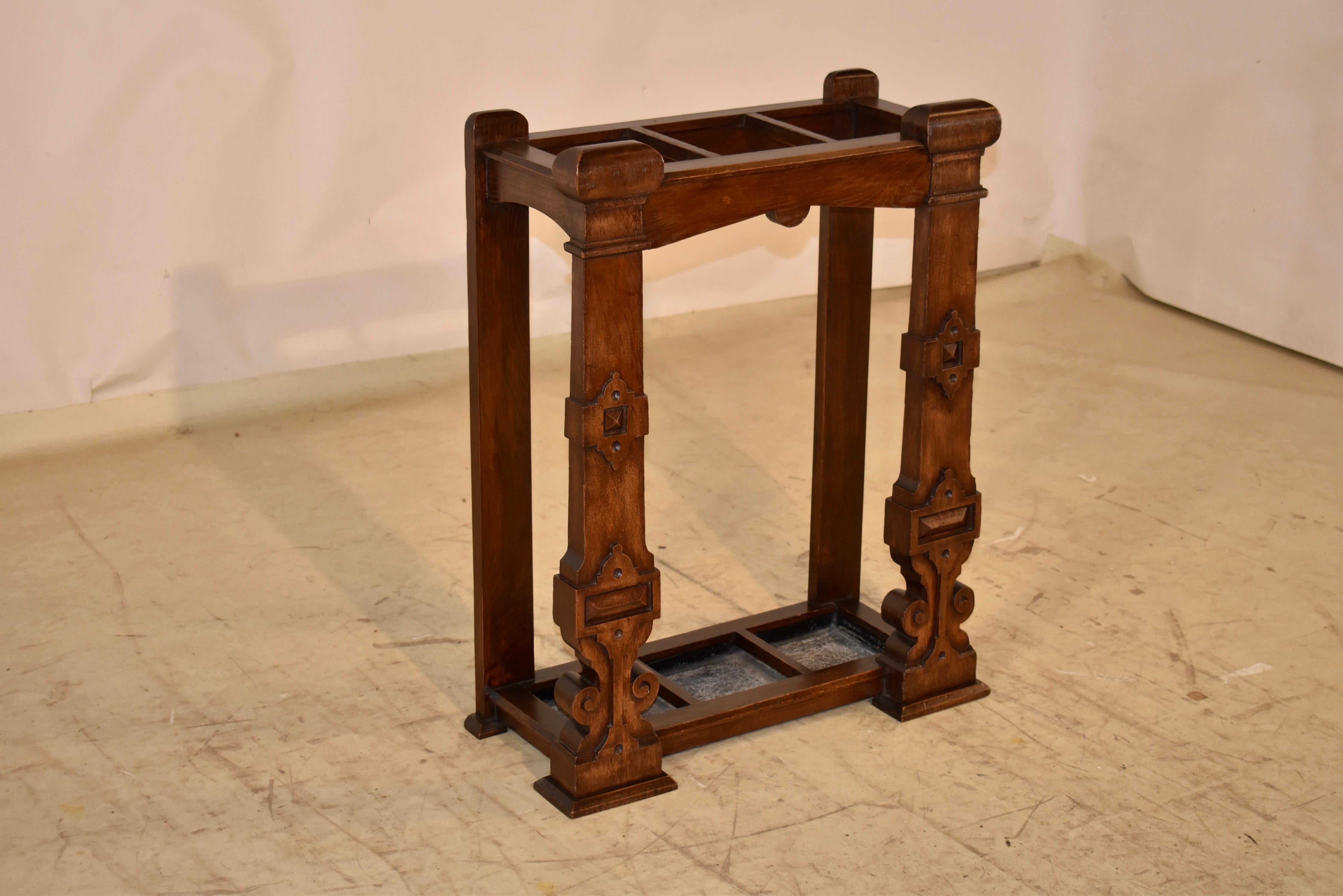 Late 19th century oak umbrella or cane stand from England.  This is a lovely umbrella stand, made solidly from nice English oak.  The back legs are simple, to allow for easy placement against a wall, and the front legs are carved with embellishments