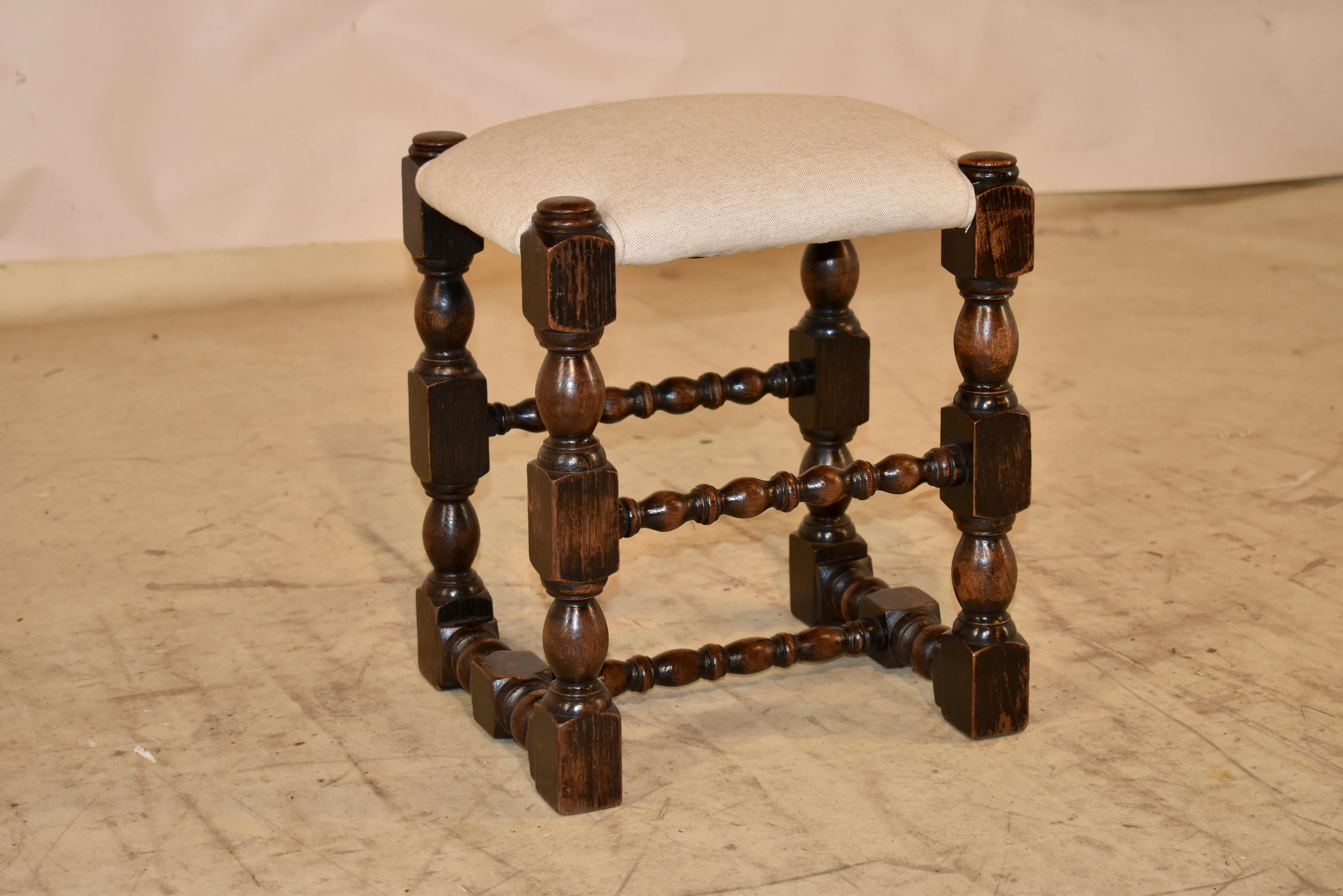 Sgabello in legno di quercia del XIX secolo proveniente dall'Inghilterra con seduta imbottita di recente in lino.  La seduta permette di esporre la parte superiore del telaio, un aspetto davvero bello per questo sgabello.  La struttura è composta da