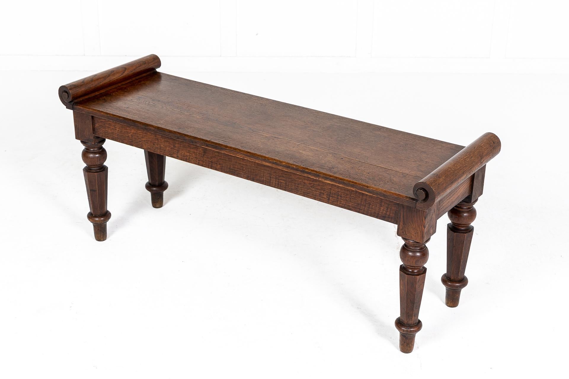19th century English window seat constructed in oak with a plank top and deep scrolled ends. Standing on thick turned and tapering octagonal legs ending in neat feet.

Nice original colour, circa 1835.
 