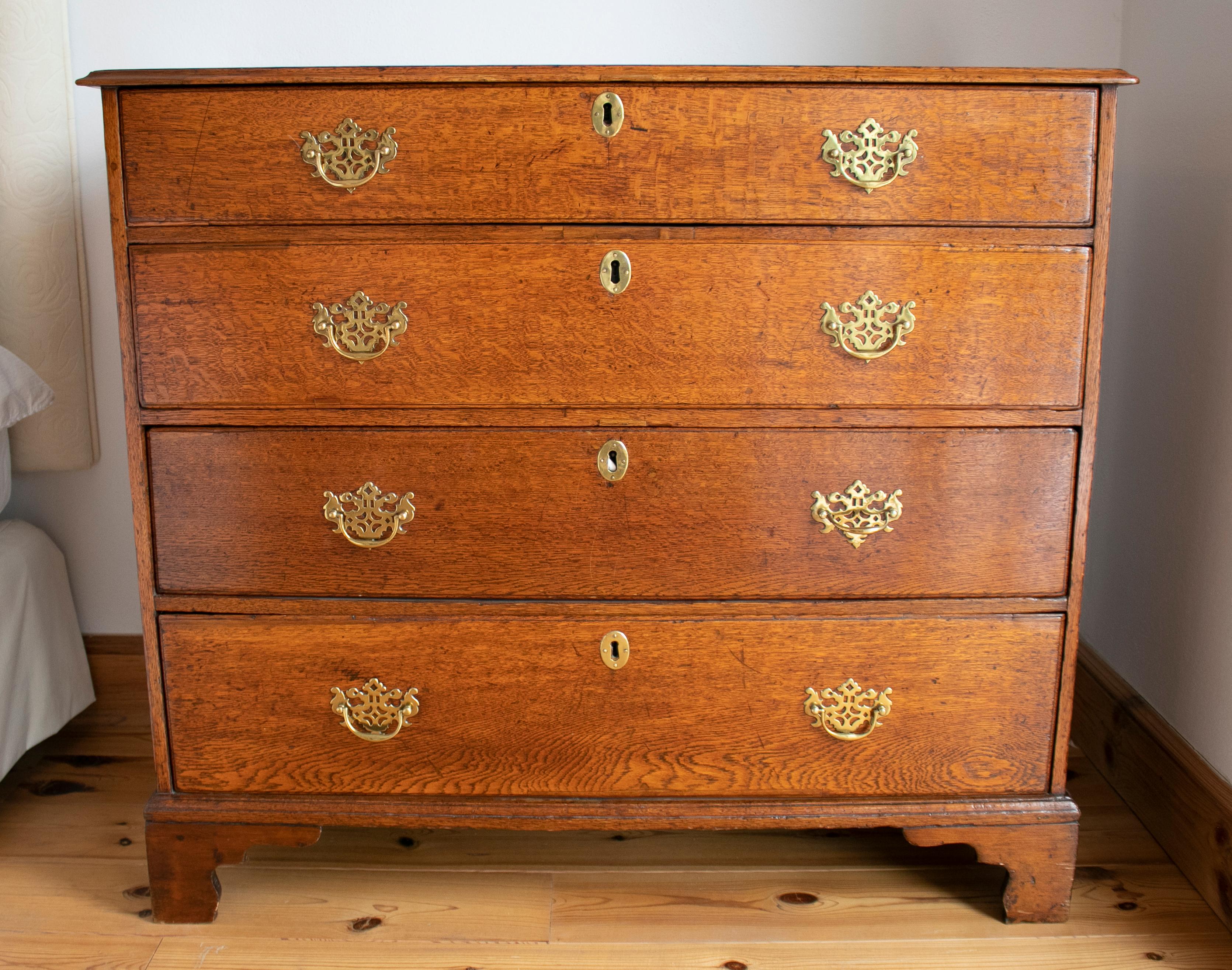 19th century English oakwood four-drawer chest with bronze fittings.