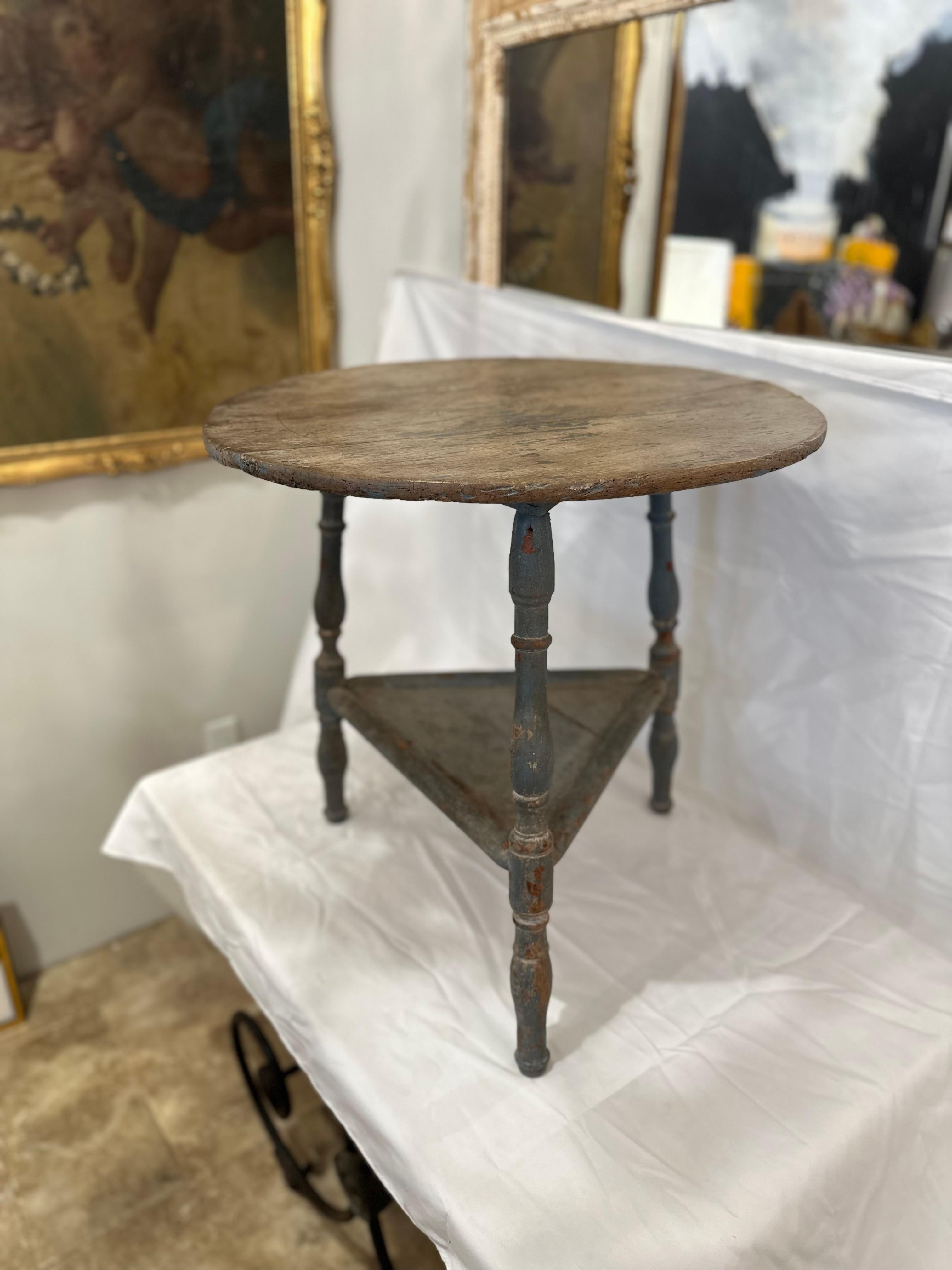 The 19th Century English Original Paint Cricket Table is a charming relic of bygone days, steeped in history and character. Crafted with care and attention to detail, this table features a circular top supported by three gracefully curved legs,