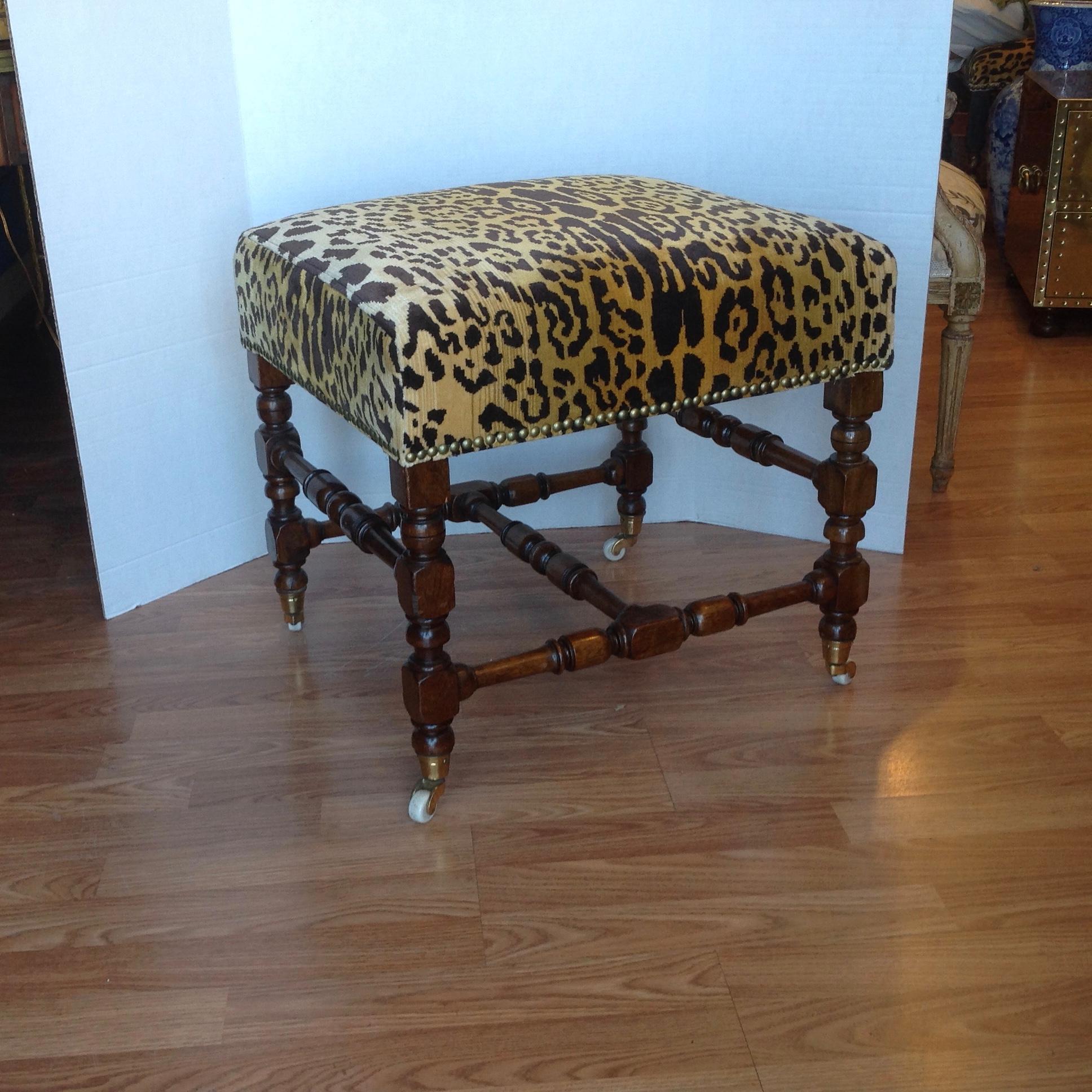 A finely crafted Edwardian bench topped with an exquisite faux leopard fabric
accented by nailheads. The ottoman retains its original castors.