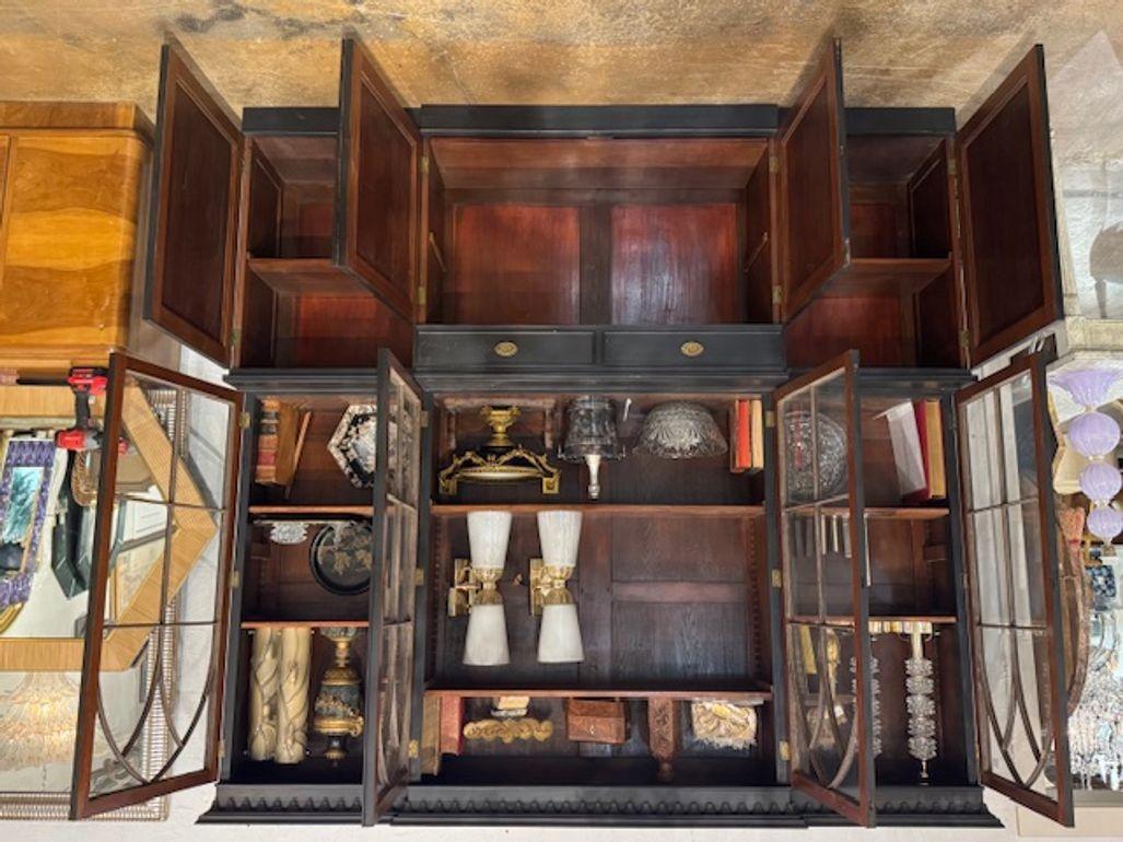 This 19th Century English Painted Mahogany Breakfront Cabinet features a matt black color and a and a traditional breakfront design. This handsome piece would be wonderful for a living room or study.  Perfect for storing items while also serving as