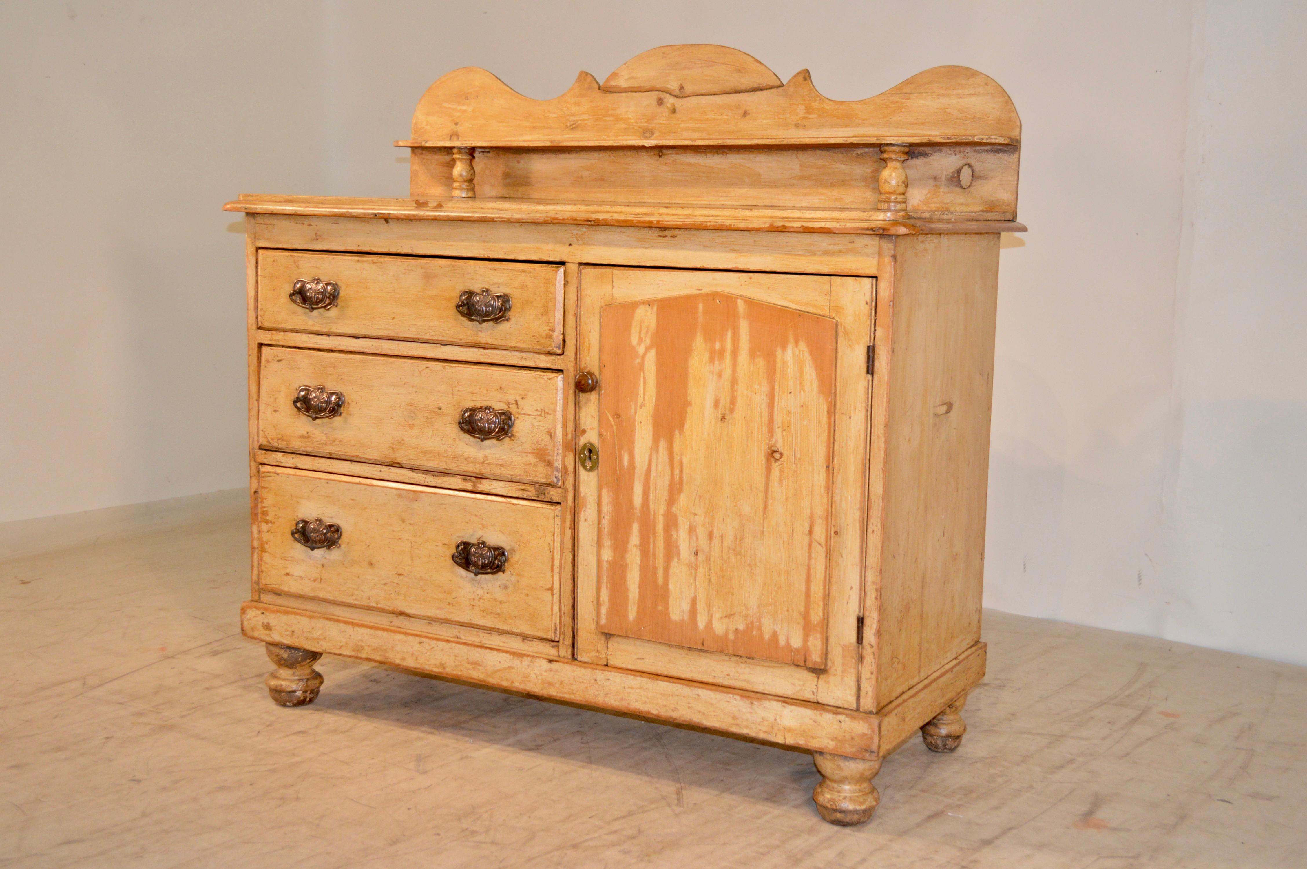 Late 19th century English pine buffet with original yellow paint finish. The backsplash is scalloped and has an old repair. There is a small shelf attached to the backsplash and the top has a beveled edge around the top. The case contains three