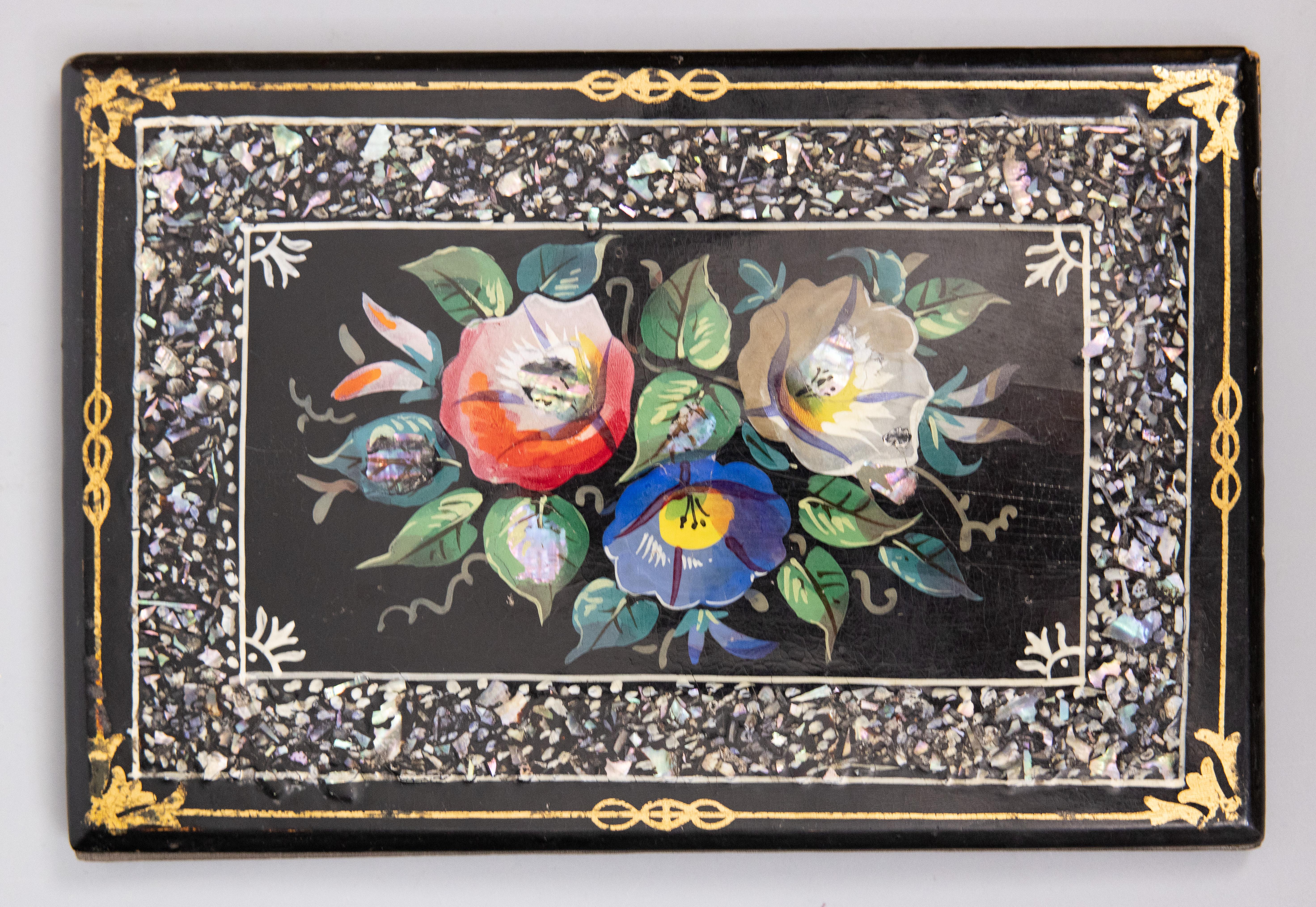 A lovely antique 19th-Century English black lacquer papier mâché folio or desk blotter. This fine folio has a hand painted floral design with inlaid mother of pearl details and a gilt decorative border.

Dimensions
6