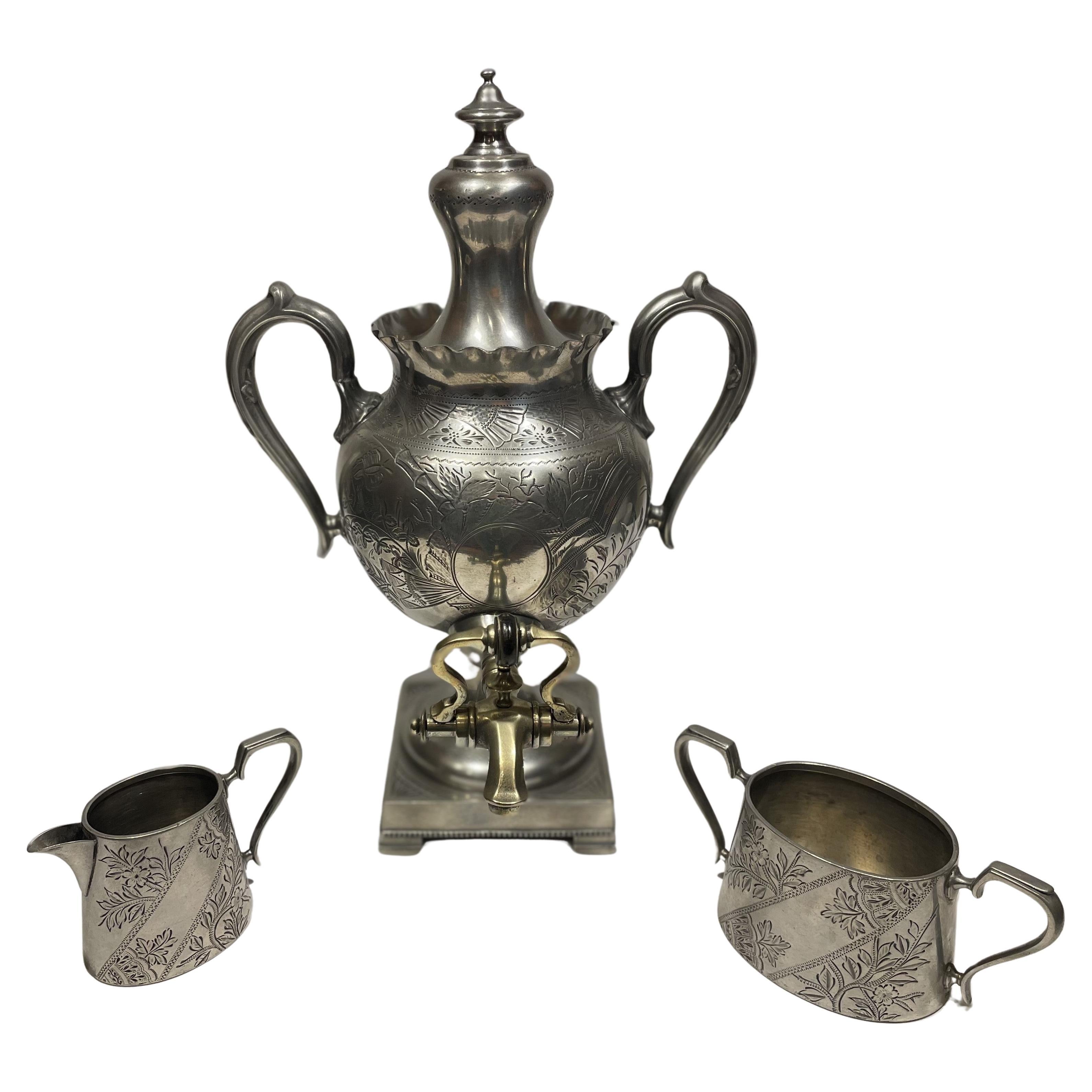 Dating to 1870 and made in Sheffield, England, a locale well known for its silver design and production, this is an extremely well-preserved three-piece pewter and brass tea service. It consists of a stately and sizable tea urn, with matching sugar