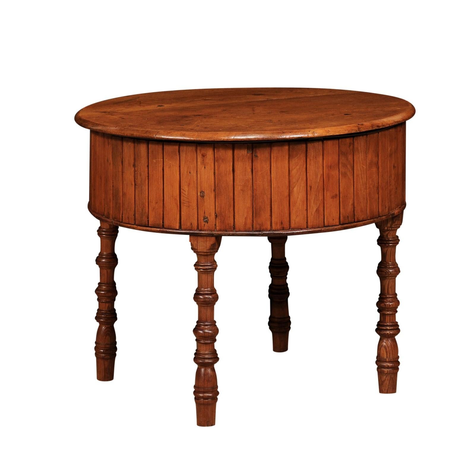 An English pine drum table from the 19th century with removable circular top, metal basin inside and four faux bamboo legs. This 19th-century English pine drum table is a delightful blend of functionality and rustic charm. Its removable circular top