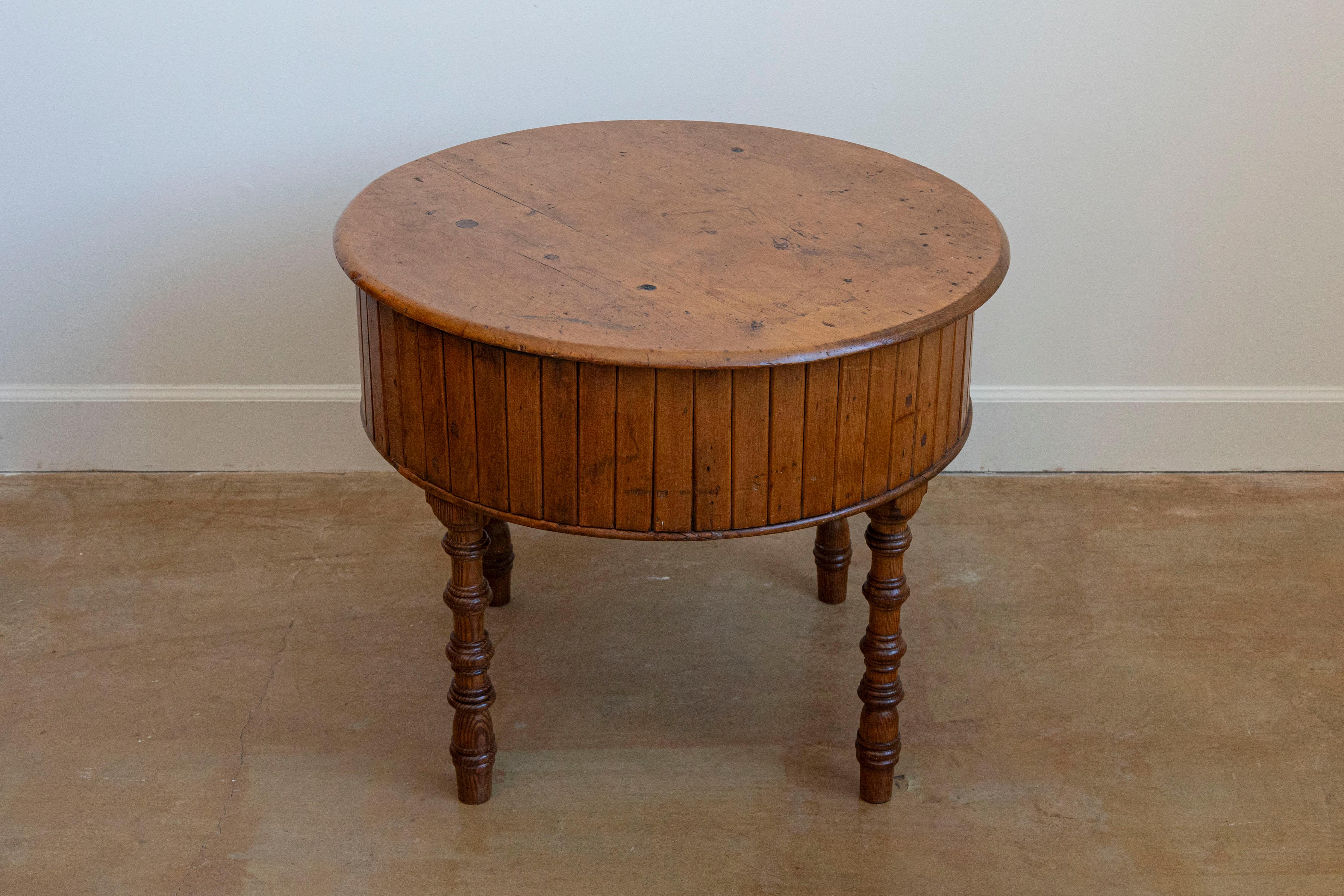 An English pine drum table from the 19th century with removable circular top, metal basin inside and four faux bamboo legs. This 19th-century English pine drum table is a delightful blend of functionality and rustic charm. Its removable circular top