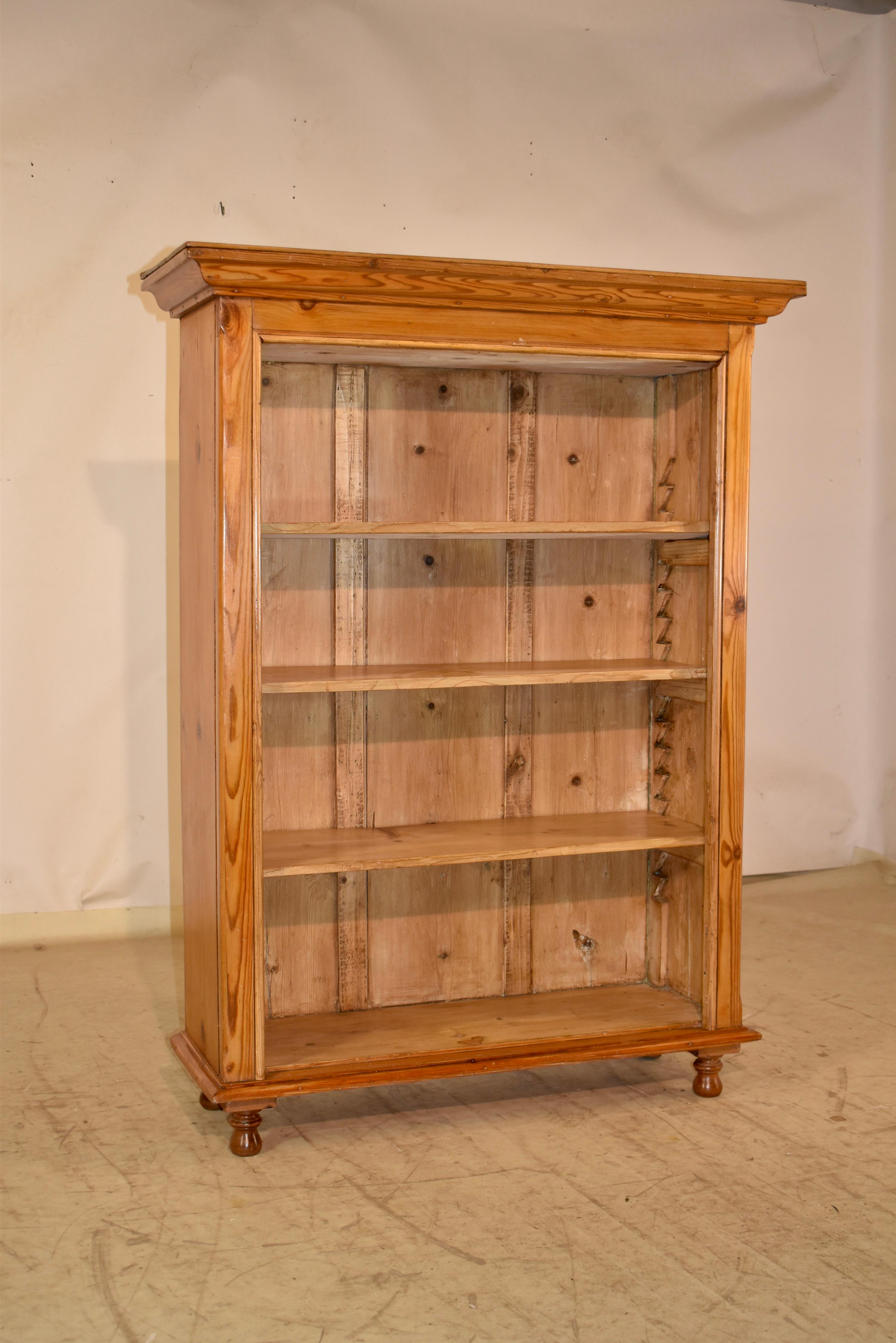 Bibliothèque en pin du 19e siècle, originaire d'Angleterre.  Les lignes sont simples pour faciliter l'installation dans la maison ou le bureau.  Le haut de la caisse est orné d'une majestueuse moulure en forme de couronne, qui s'étend jusqu'aux
