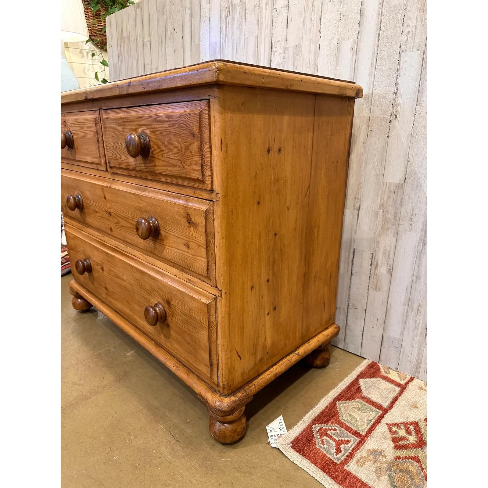 This is a lovely antique pine chest! This piece dates to the 19th century and has lovely patina. The wood has a warm glow, that is accented perfectly by the darker stained knobs. Being a two over two design with a casual simple feel. This chest