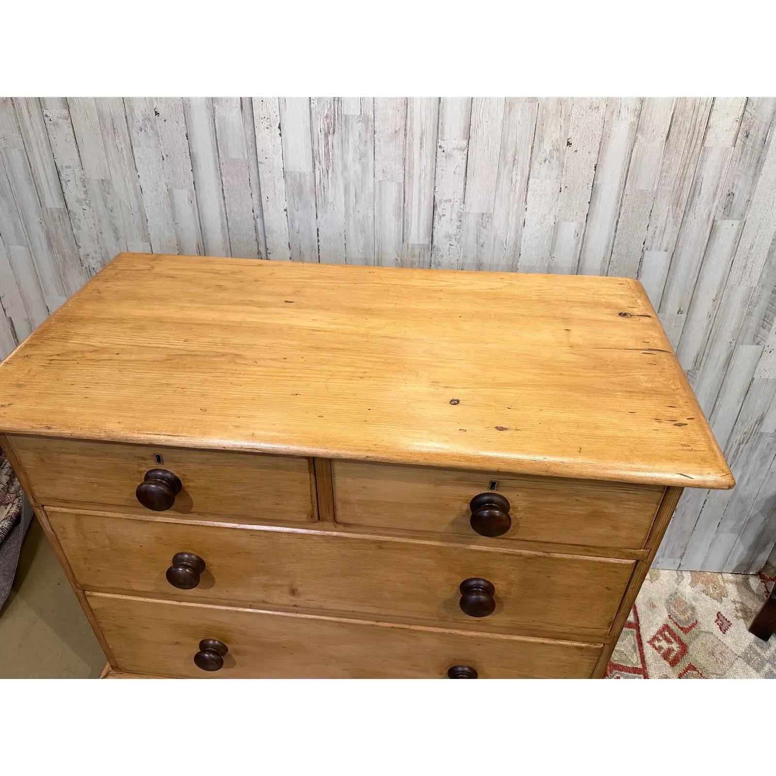This is a lovely antique pine chest! This piece dates to the 19th century and has lovely patina. The wood has a warm glow, that is accented perfectly by the darker stained knobs. Being a two over two design with a casual simple feel. This chest