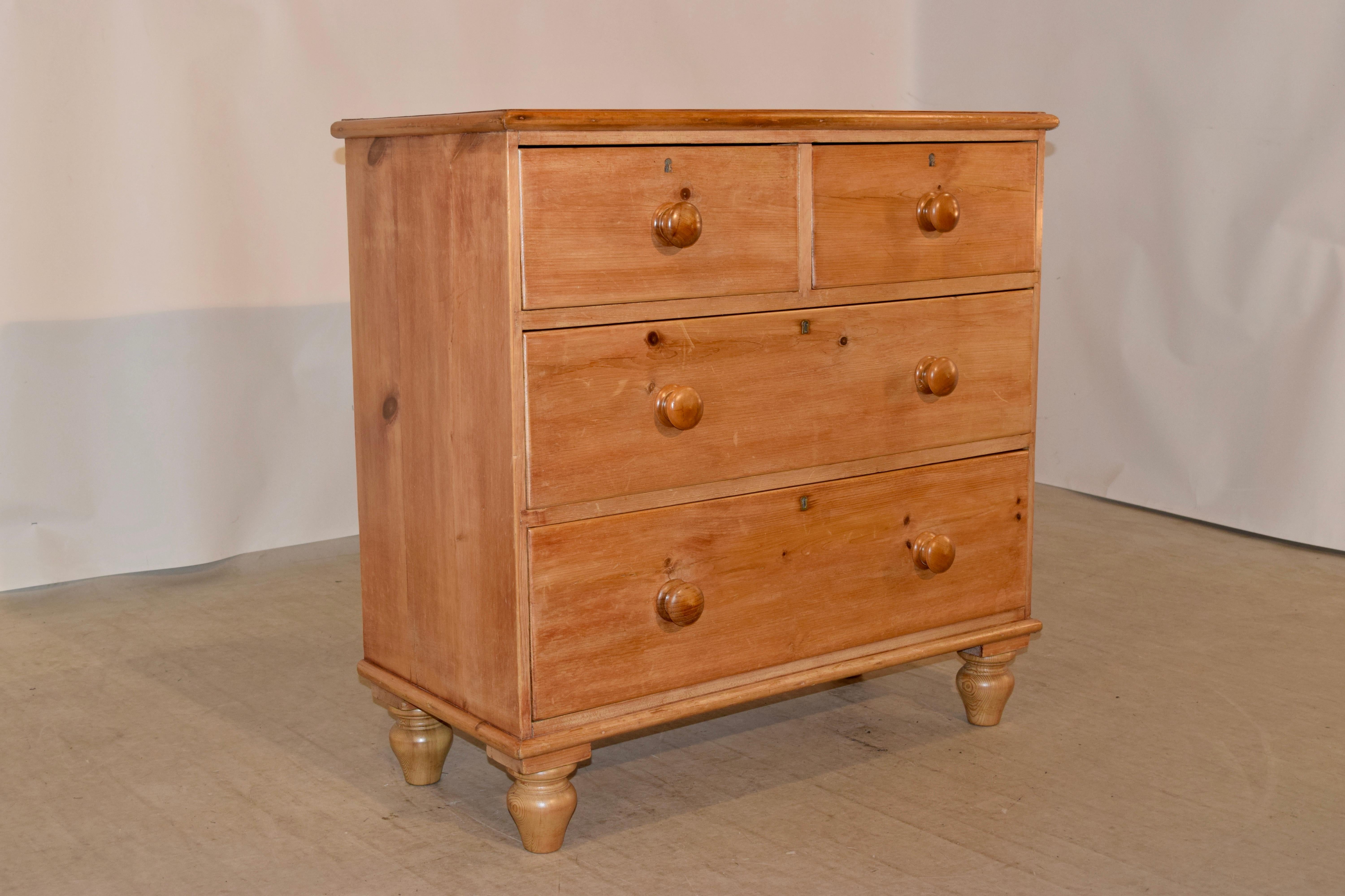 19th century pine chest from England with a beveled edge around the top following down to simple sides and two-drawer over two drawer configuration. The bottom of the case is molded and is raised on hand turned feet.