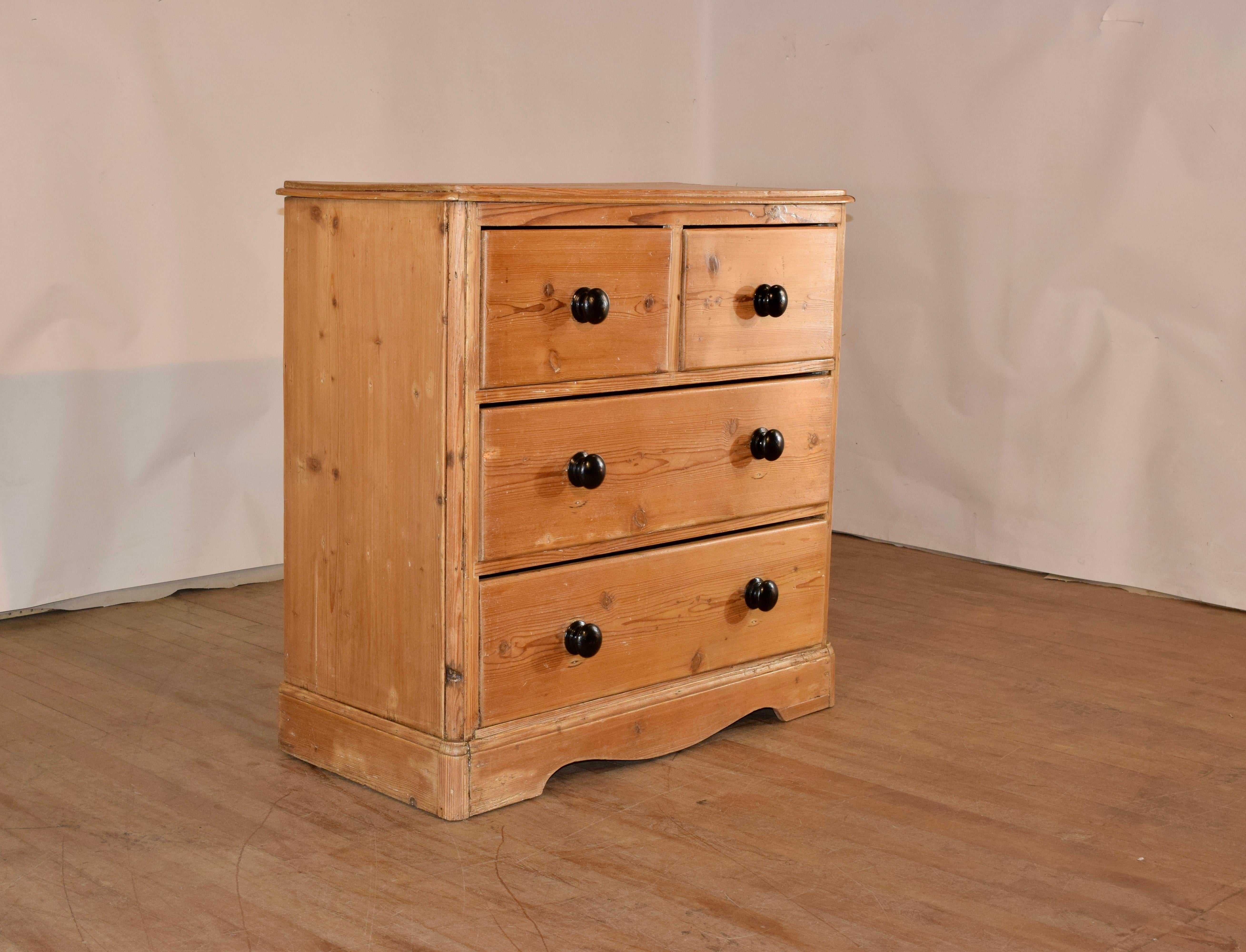 19th century pine chest of drawers with a beveled edge around the top, following down to simple sides and two drawers over two drawers, all over a banded base, with scalloping in the front.  