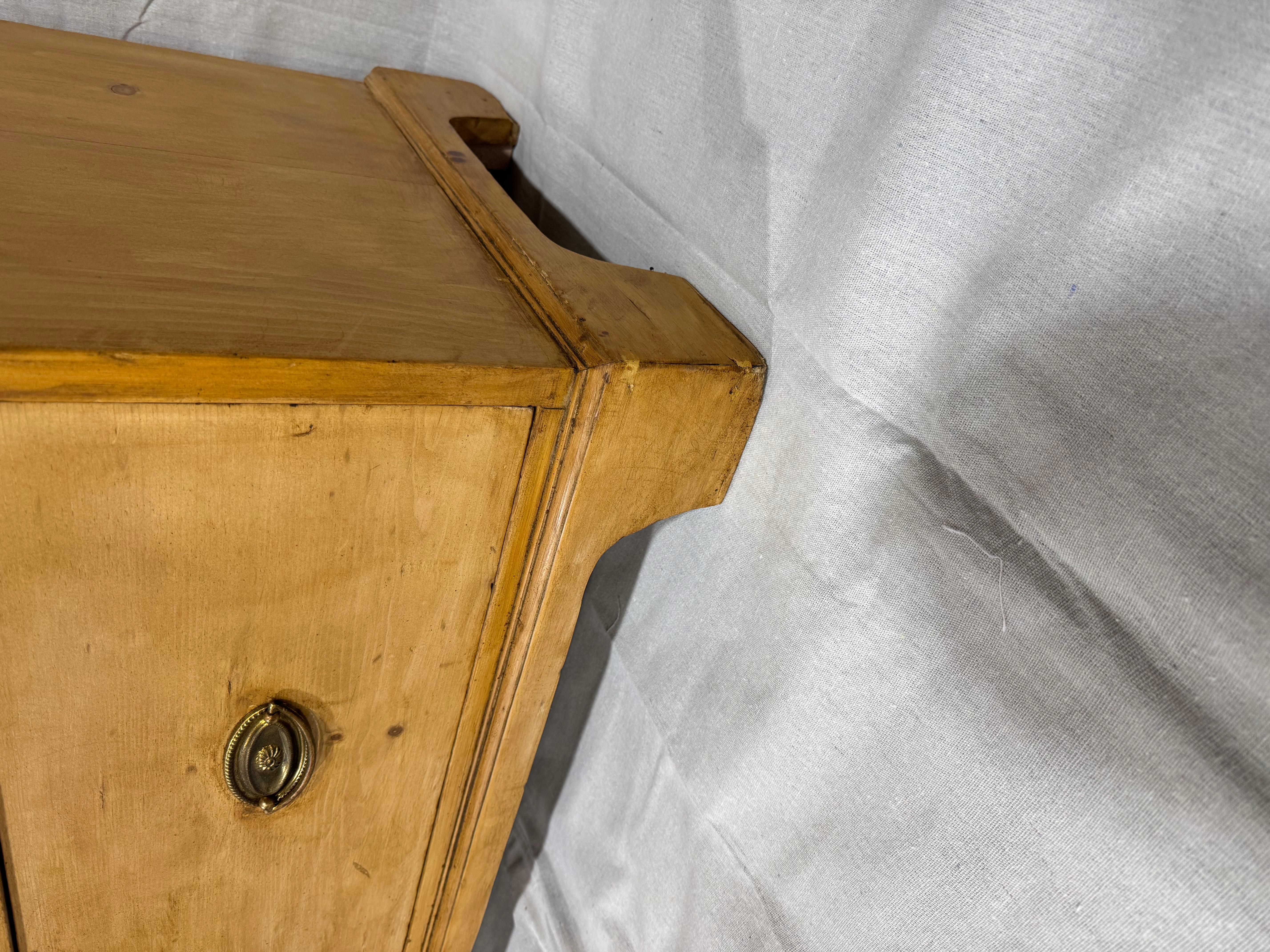 This is a lovely antique English pine chest! This piece dates to the 19th century and has lovely patina. The wood has a warm glow that is accented perfectly by brass pulls. Being a two over three design with a casual simple feel. This chest would