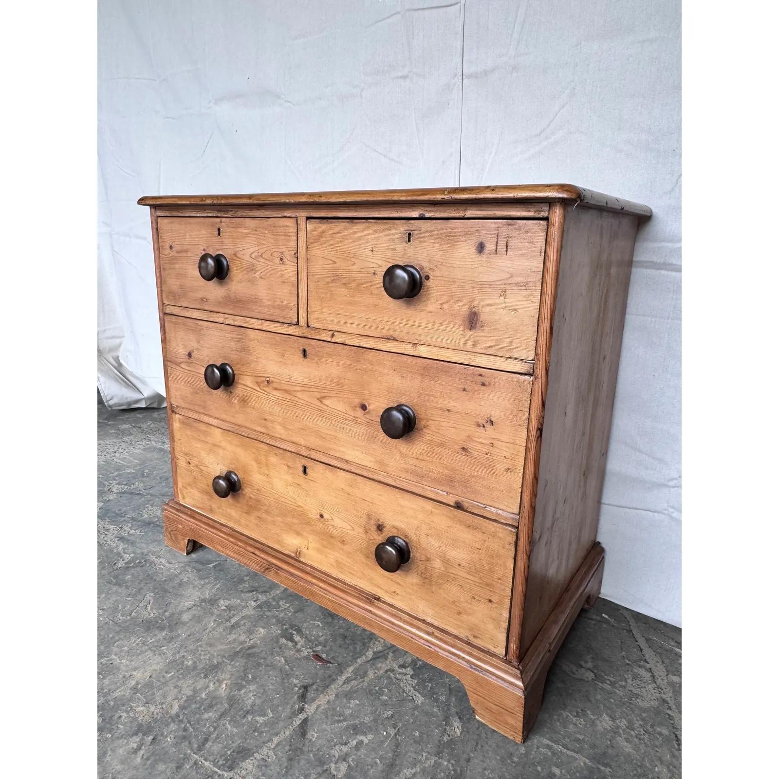 This is a lovely antique pine chest! This piece dates to the 19th century and has lovely patina. The wood has a warm glow, that is accented perfectly by the darker stained knobs. Being a two over two design with a casual simple feel. This chest