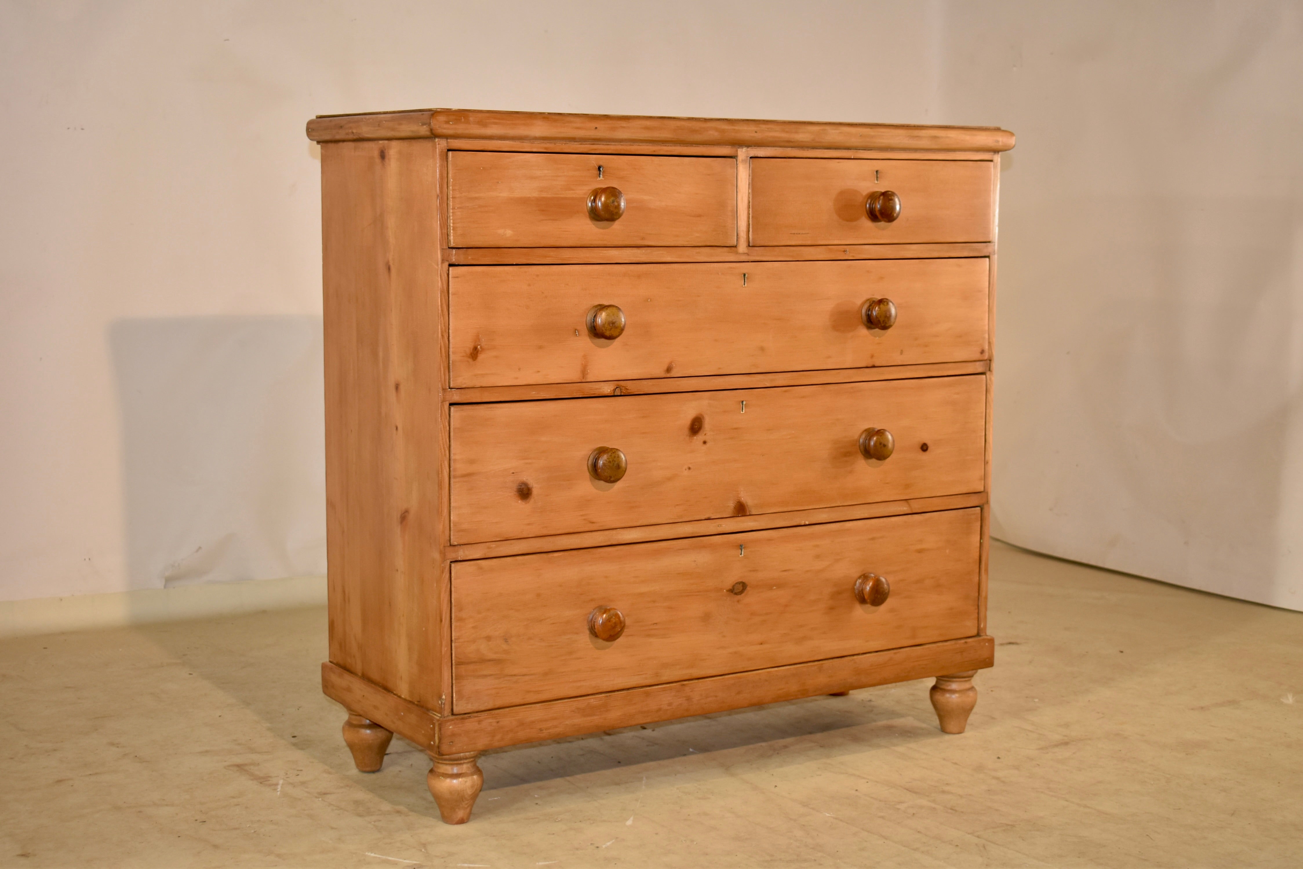 19th Century pine chest of drawers with a single board top surrounded by a molded edge, following down to simple sides. The case has two over three drawers in the front, and the case is supported on hand turned feet. This chest is a very nice size