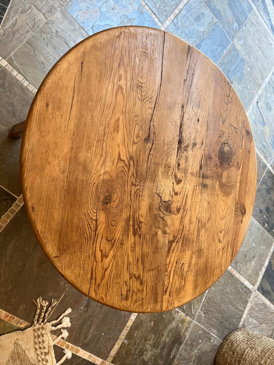 A charming 19th-century English Pine Cricket Table featuring a lower shelf. Its rustic appeal and sturdy construction evoke the simplicity and practicality of bygone eras, making it a delightful addition to any space with its vintage charm and