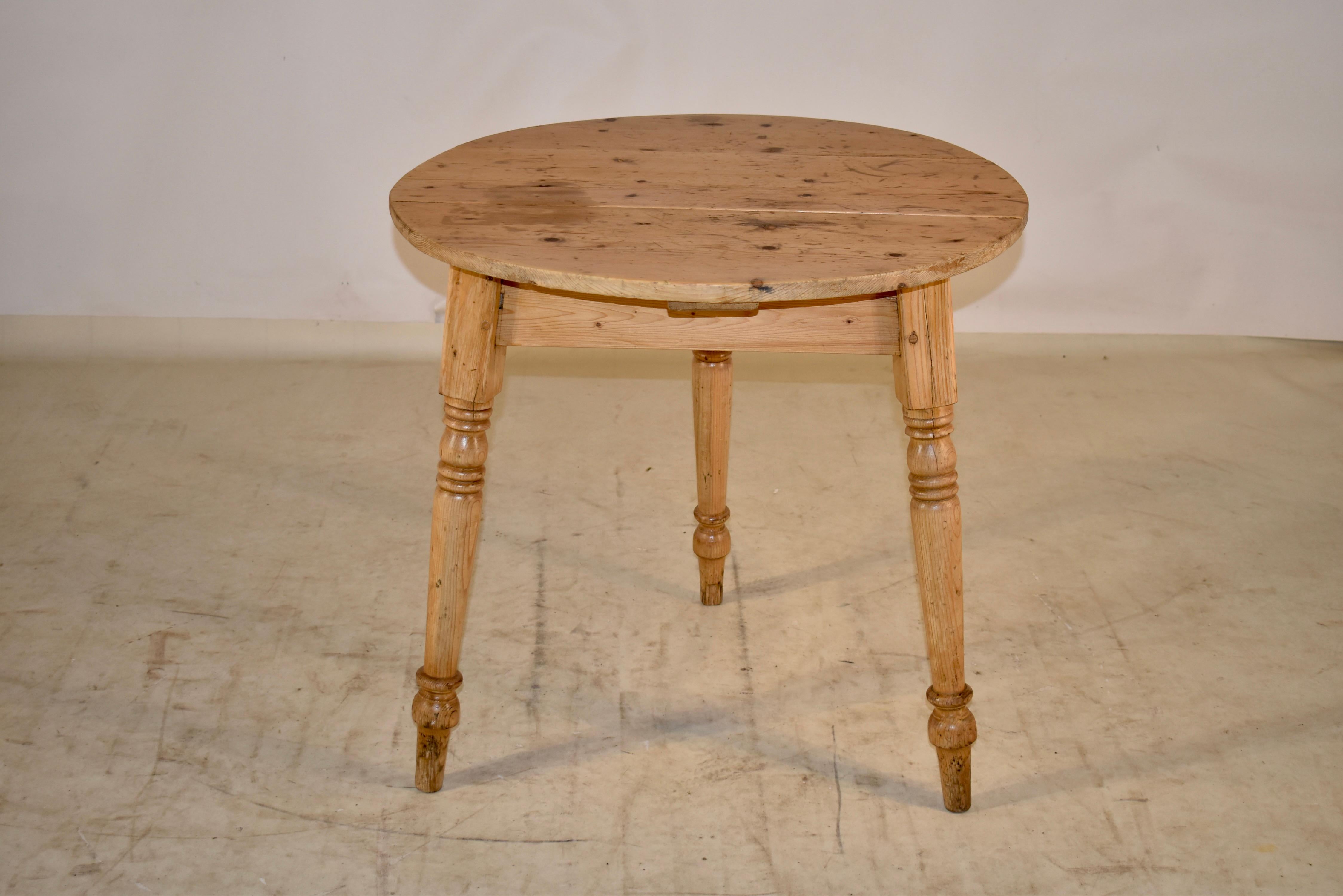 19th century pine cricket table from England.  The top is made from planks and has pegged construction.  The top is supported on a simple apron and splayed legs which have been hand turned. The table top has wonderful markings to support its age and