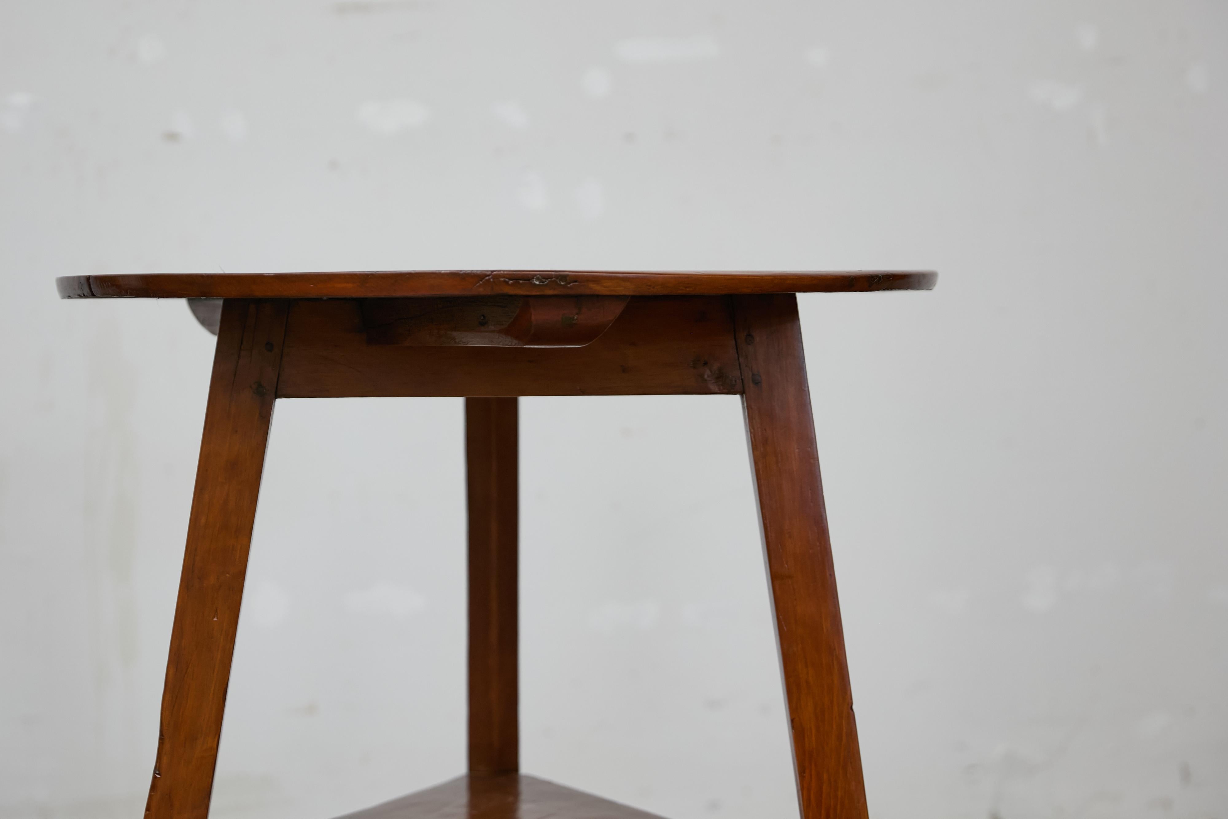 Table de cricket en pin anglais du 19ème siècle avec plateau circulaire, base tripode et étagère basse triangulaire. Cette table de grillon en pin anglais du XIXe siècle capture le charme de la simplicité rustique avec son plateau circulaire et sa