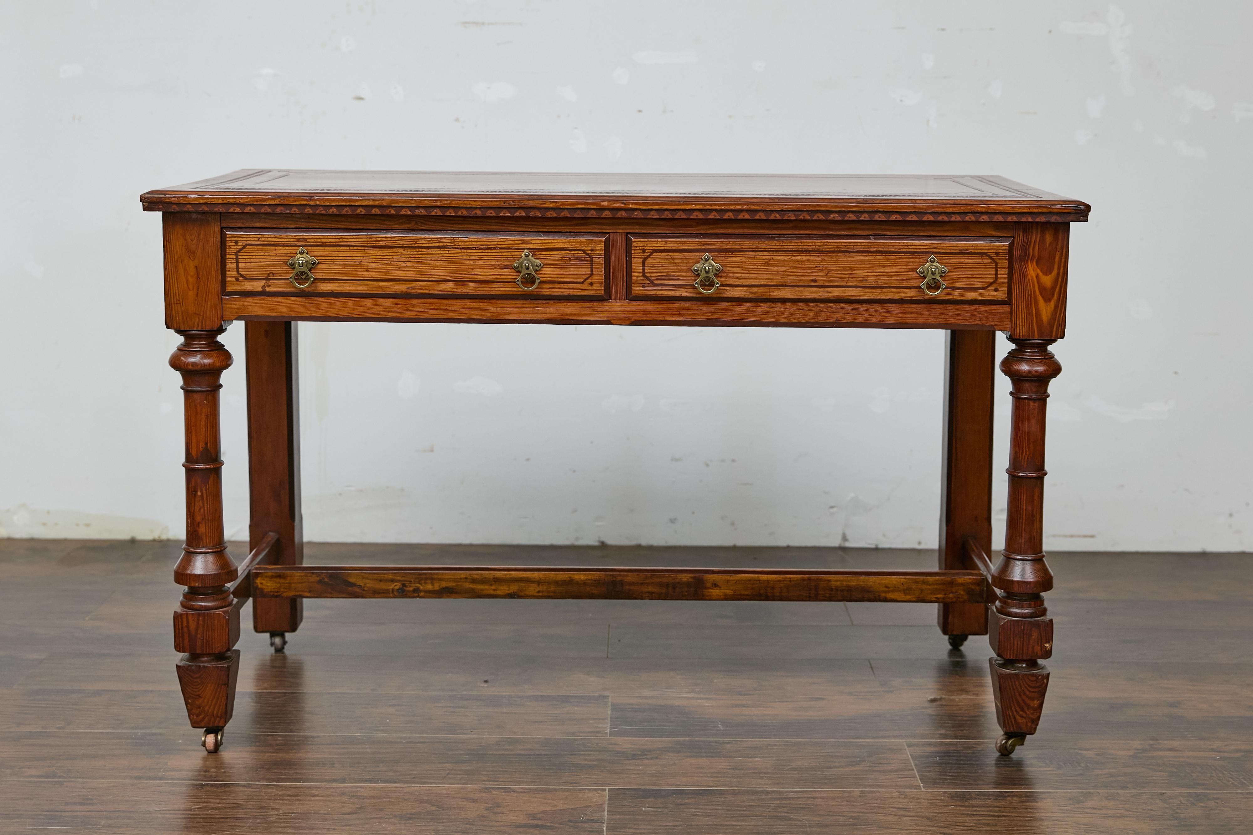 An English pine desk from the 19th century with tooled leather top. Introduce timeless charm into your home with this 19th-century English pine desk, a piece that blends practicality with classic design. Featuring a beautifully patinated tooled