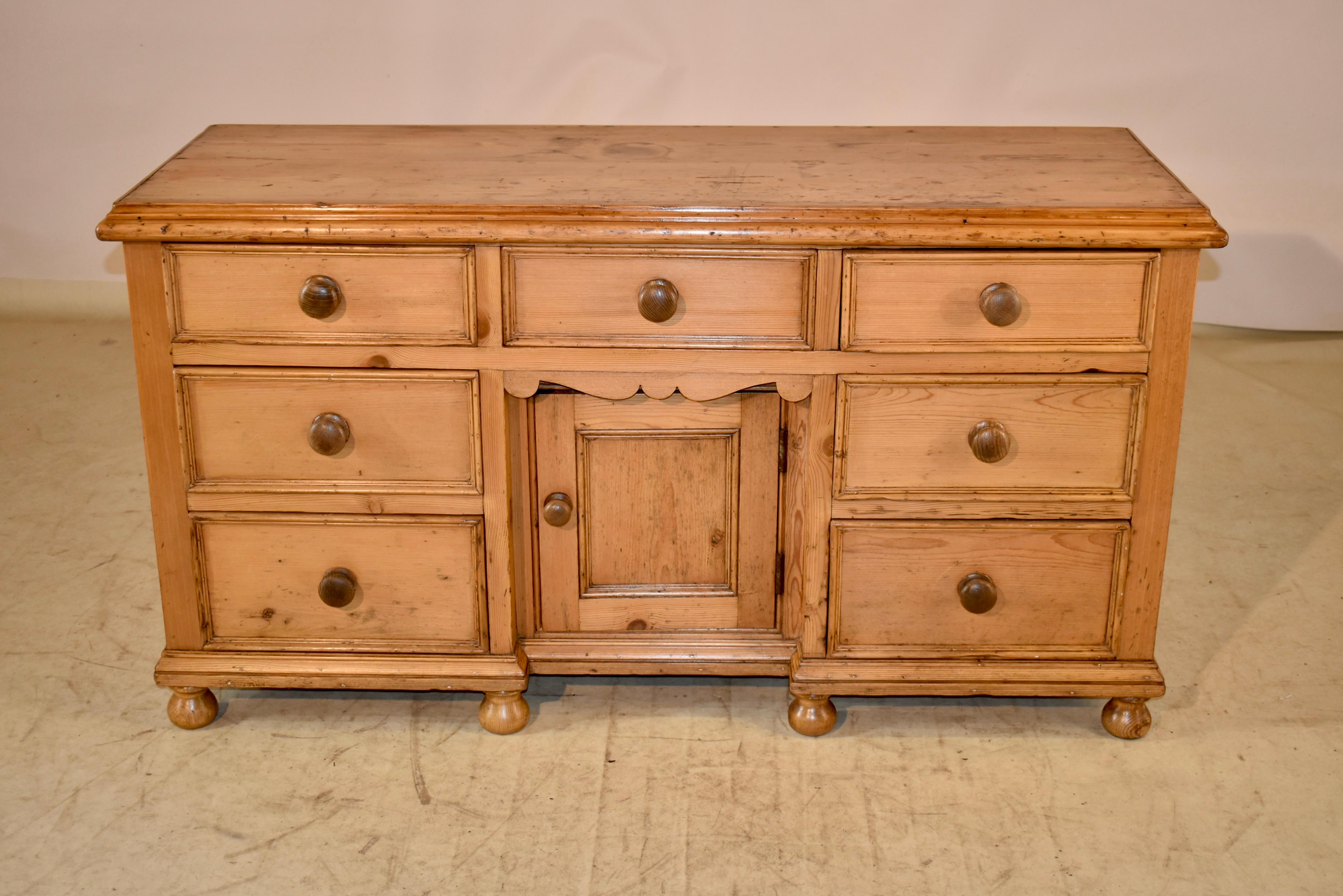 19th century lovely pine dresser base from England.  The top has rich graining, and has loads of character.  The top is surrounded by a shaped molding.  The top follows down to paneled sides and three drawers over two banks of two drawers each,