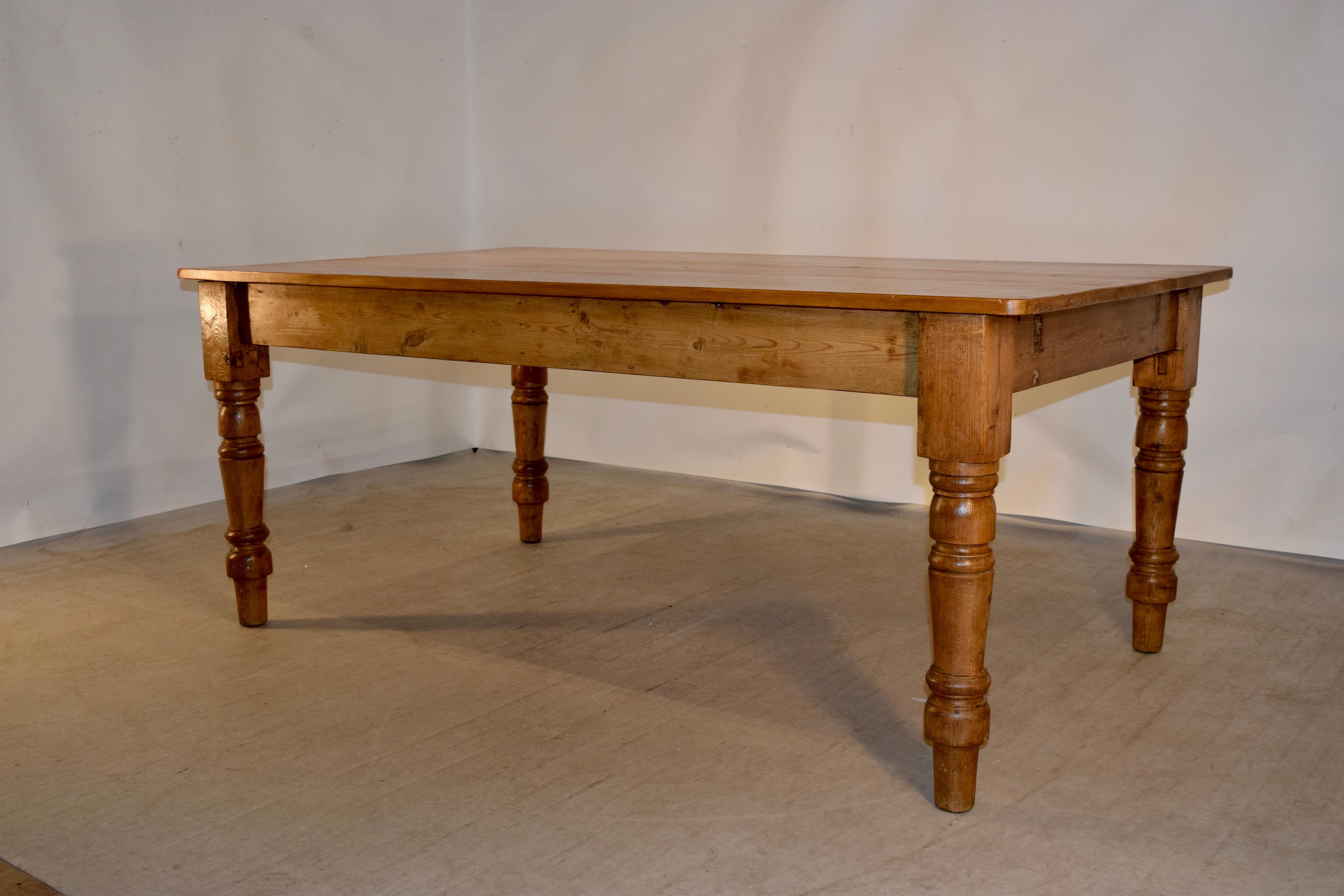 19th century English pine farm table with a plank top and simple apron. The apron height is 24
