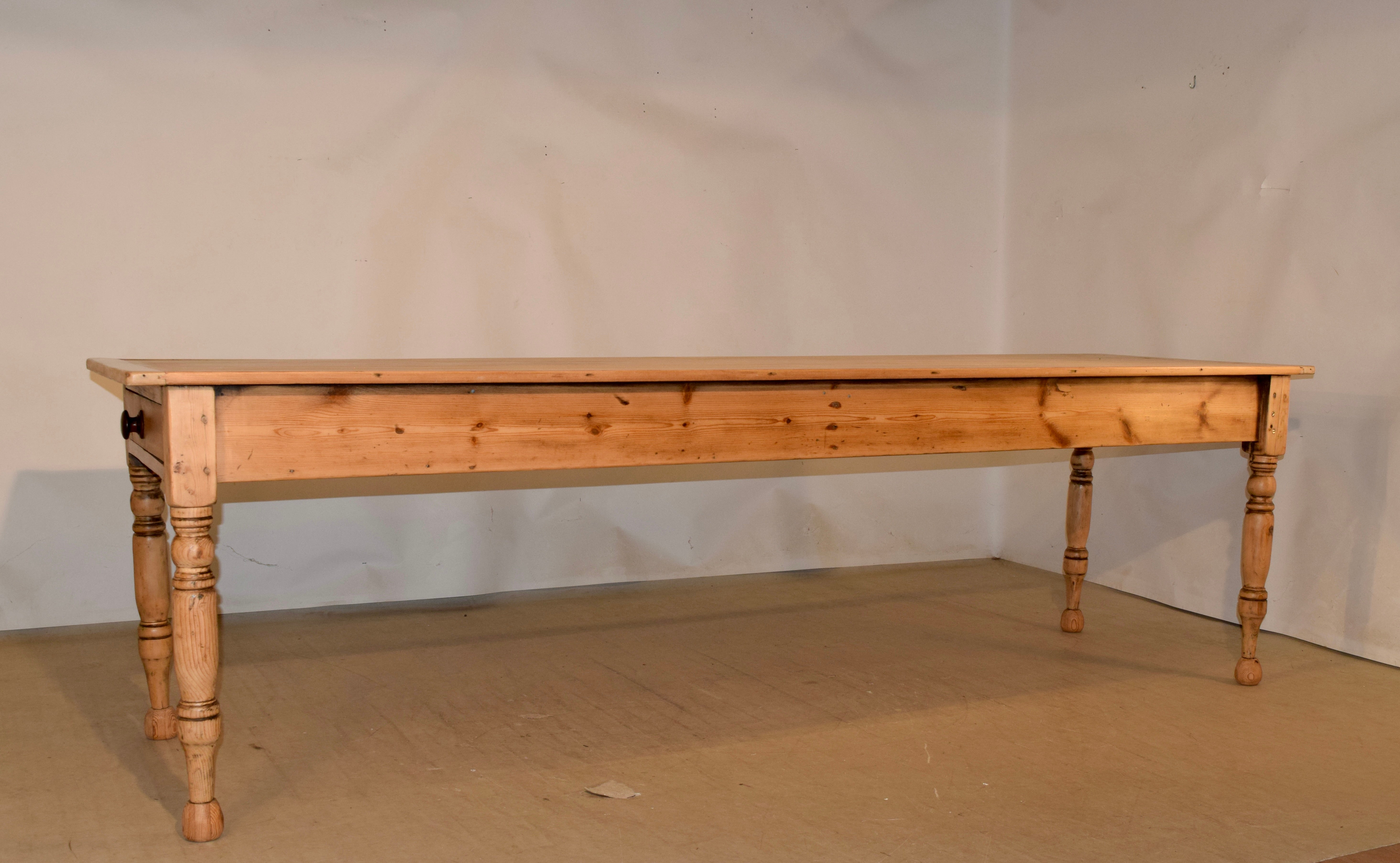 19th century English farm table made of pine. The top is made from five planks, and is banded on the ends with sycamore wood to prevent shrinkage. The apron is simple apron and contains a single drawer on one end. The table is supported on hand