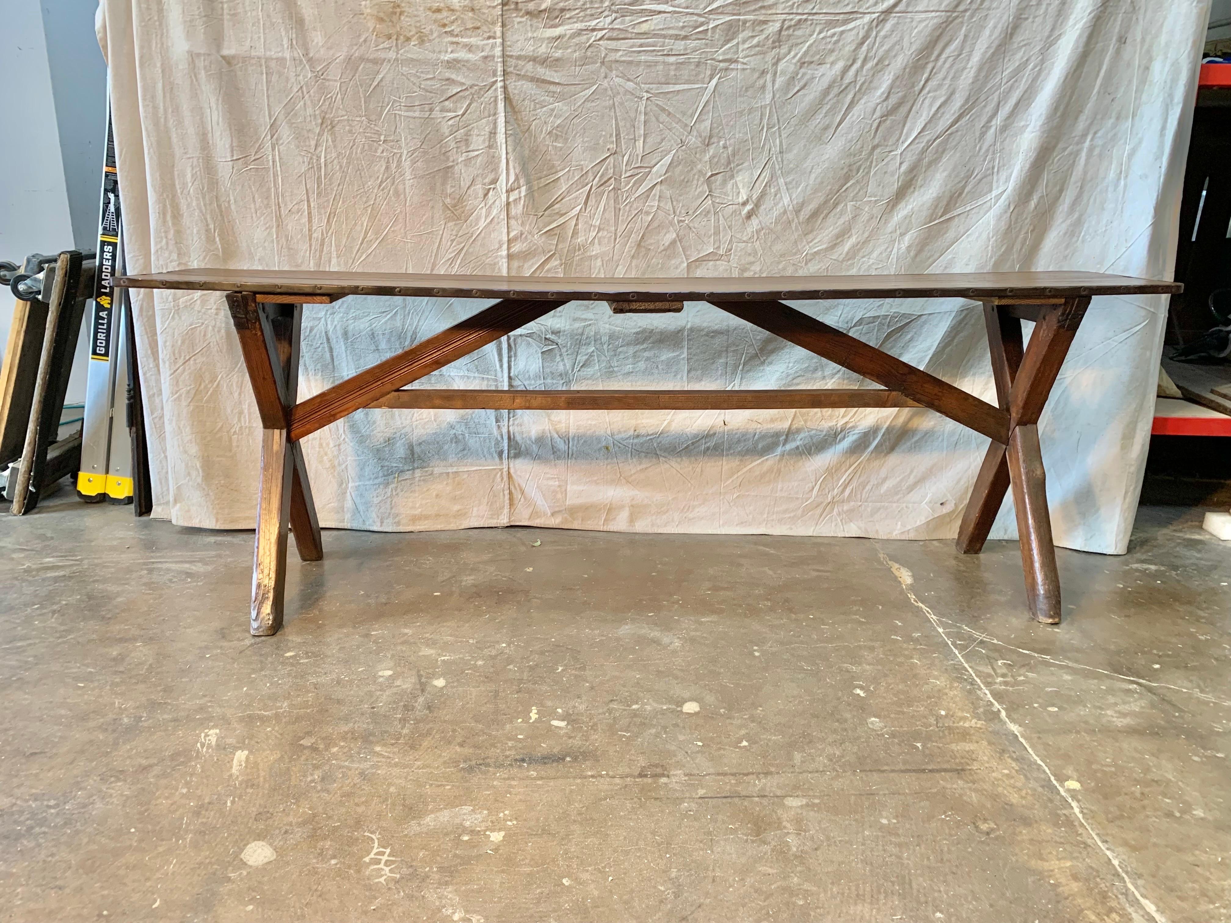 Found in the English countryside this 19th Century English Pine Sawbuck Console Table features a metal banded rectangular top sitting above a simple X-form base with cross stretcher. Rustic, yet refined, with its simple lines and beautiful patina