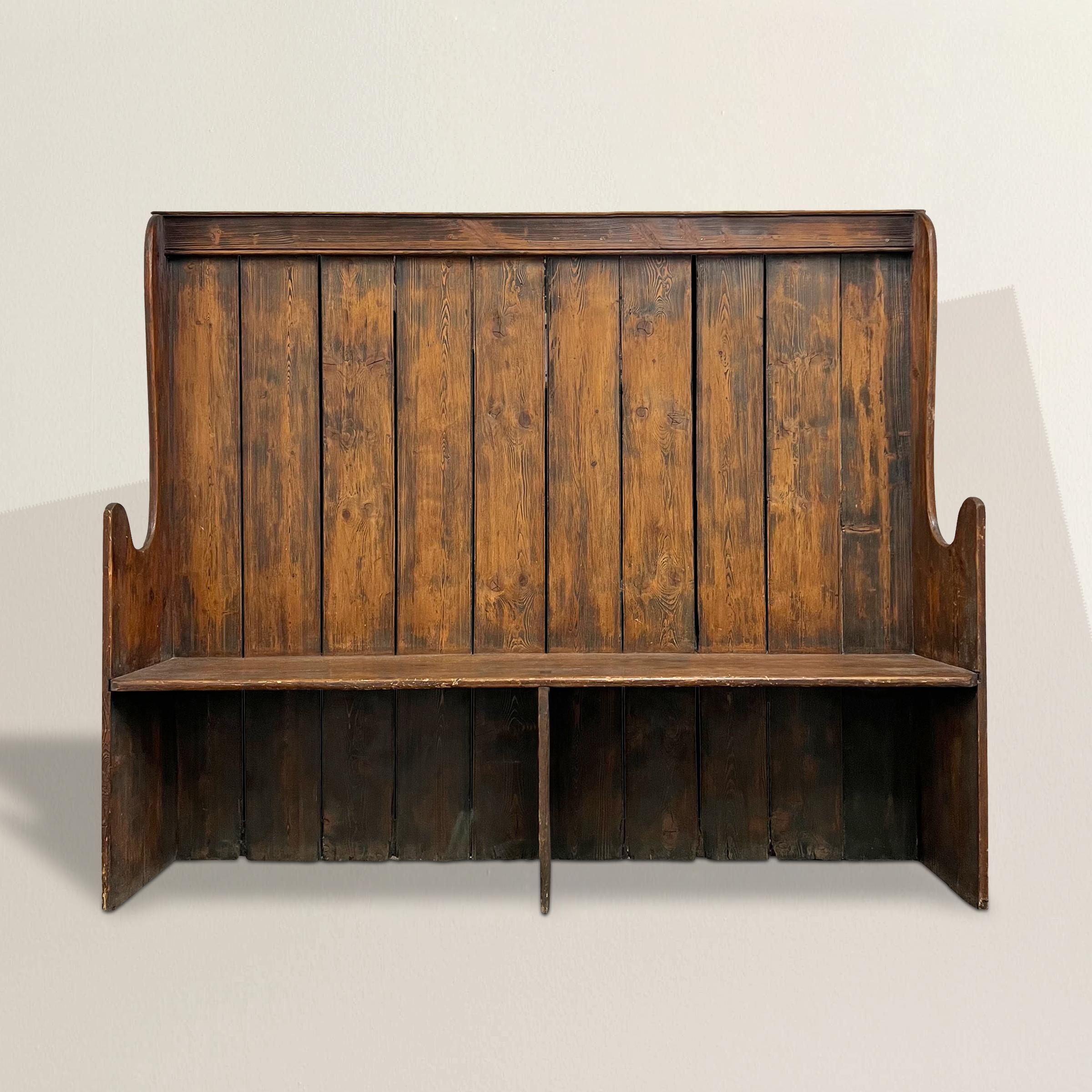 This exquisite 19th-century English Settle, handcrafted from the warm, honey-hued embrace of pine, carries the marks of time, showcasing glimpses of its original, weathered blue paint. Its charm knows no bounds, making it an ideal and versatile