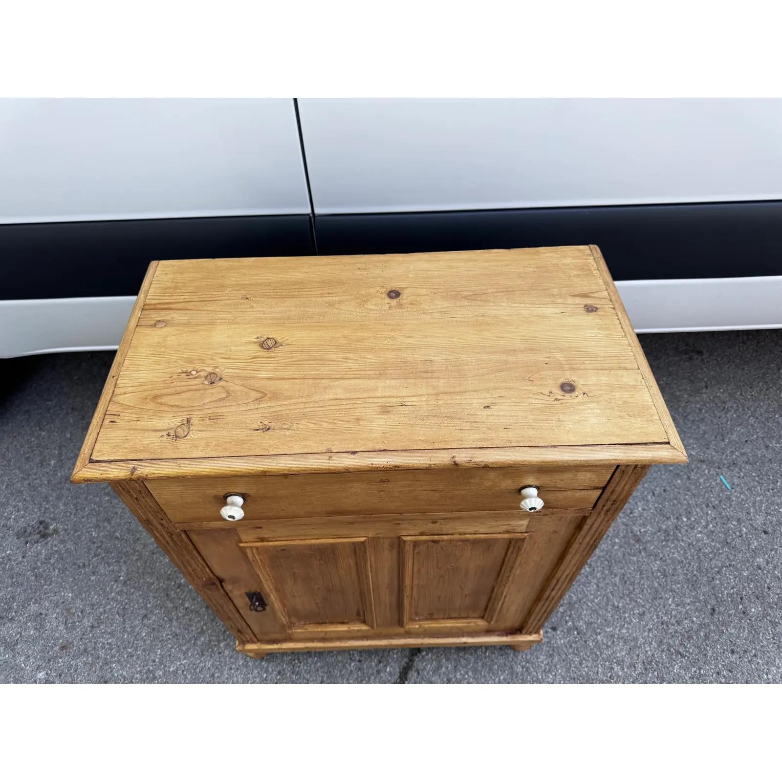 Questo è un bellissimo tavolino inglese con pomelli in porcellana! Questo tavolo in legno naturale ha un cassetto e un'anta. Il pino è molto popolare in questo momento in tutte le sue forme e questo non fa eccezione, con un tono bellissimo e una