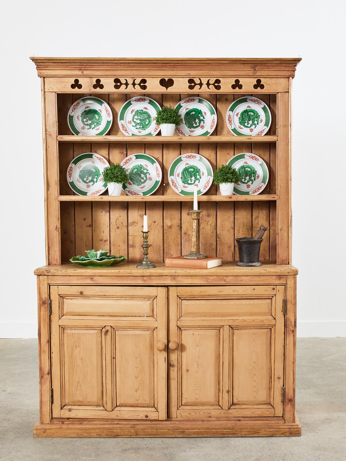 Charming 19th century country English welsh step back cupboard or dresser with plate rack. Crafted from pine having a beautifully distressed patina on the finish. The one-piece case is fronted by two storage doors opening to a shelved storage area.