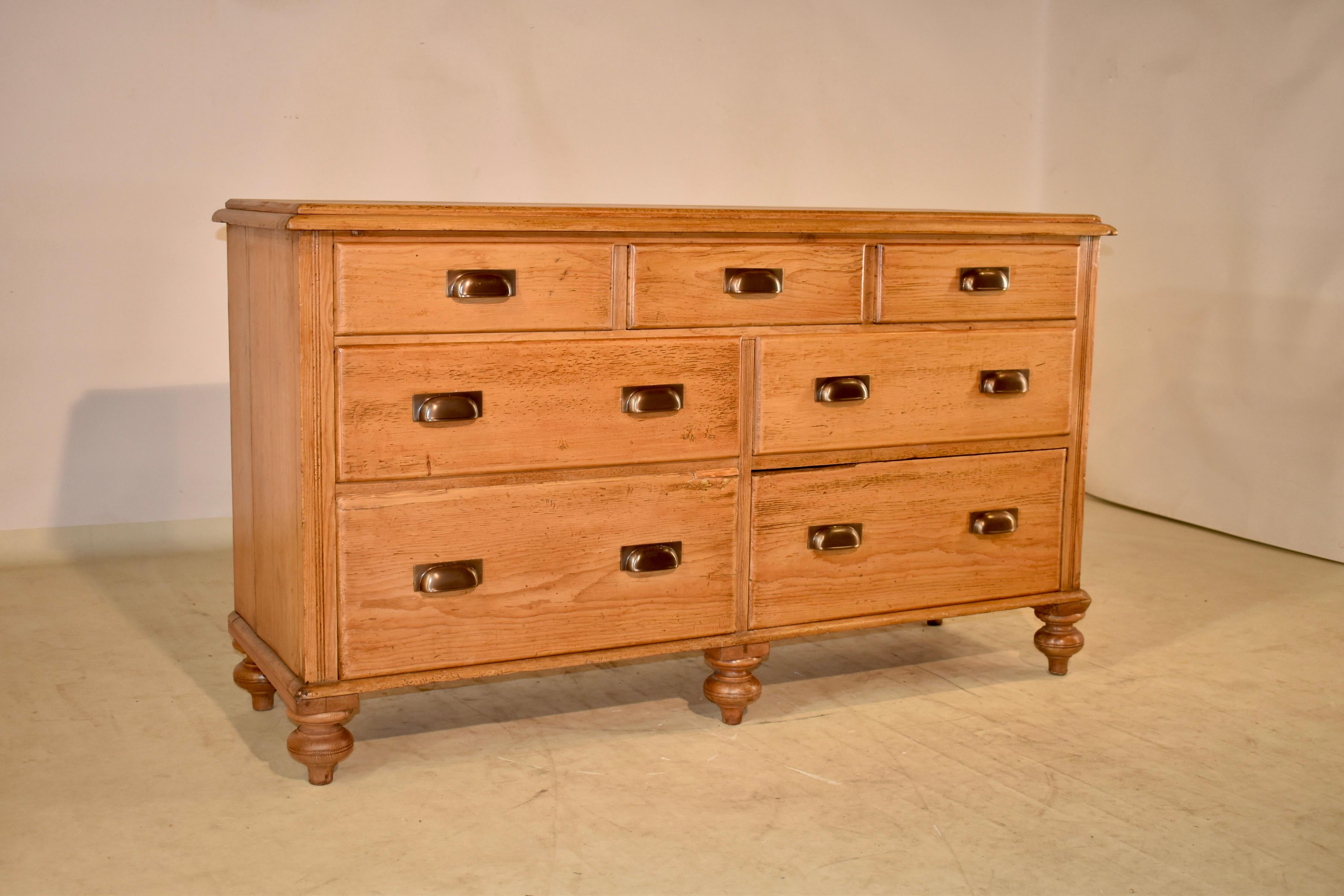 19th century pine wide chest of drawers from England with a beveled and molded edge around the top, following down to simple sides and three drawers over two sets of two drawers. The base has a molded edge as well, and the case is raised on hand