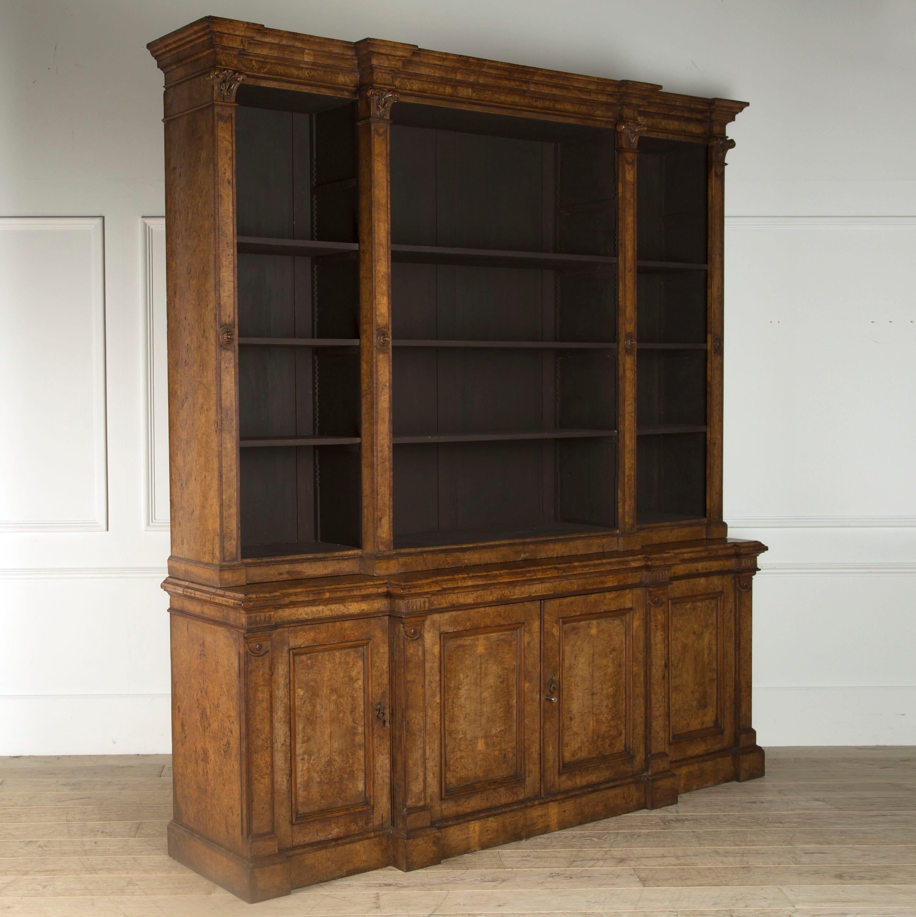 A 19th century pollard oak library bookcase of breakfront, neoclassical form with open adjustable shelves over 4 cupboard doors.