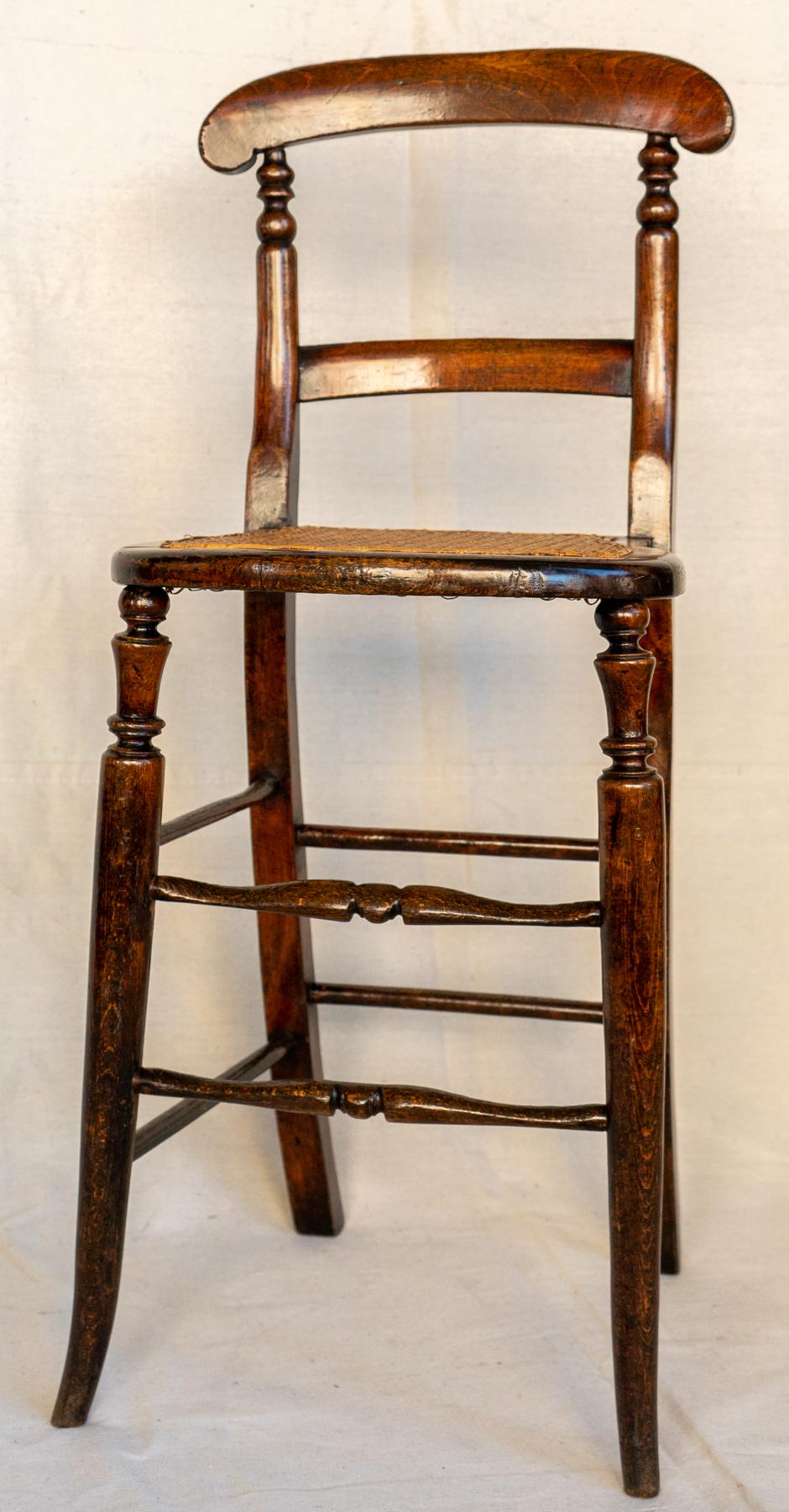19th century English posture / discipline chair. Circa 1860. Diminutive tall stool type chair, made for a child to sit upright and straight. These type of chairs became known as punishment or discipline chairs. The two from stretchers show a lot of