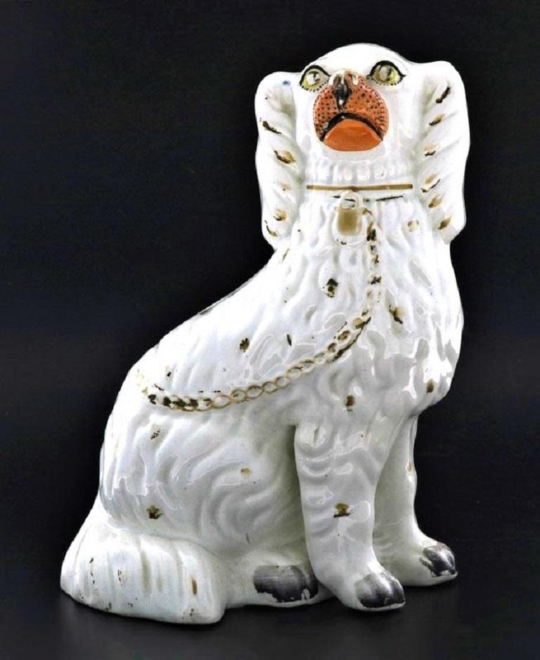 A 19th century glazed pottery Yorkshire dog sculpture, hand painted in white with gilt, orange and black accents, mid-19th century, Staffordshire, England.
Measures:
Height 10