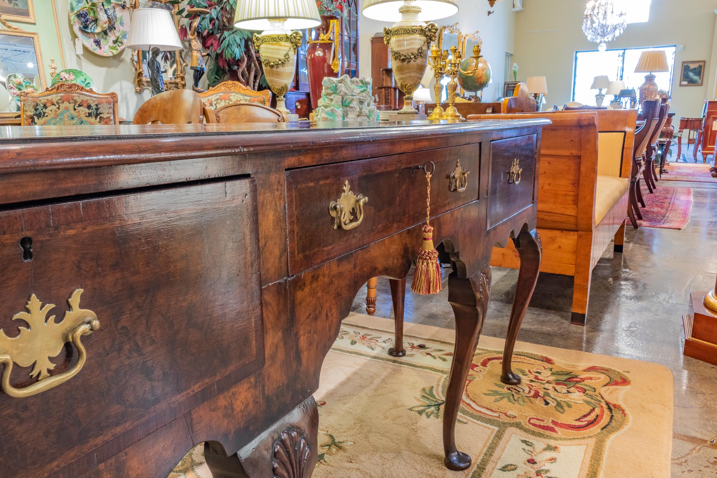 Early 19th century English burled walnut dresser base. Pad foot with carved shell knees.