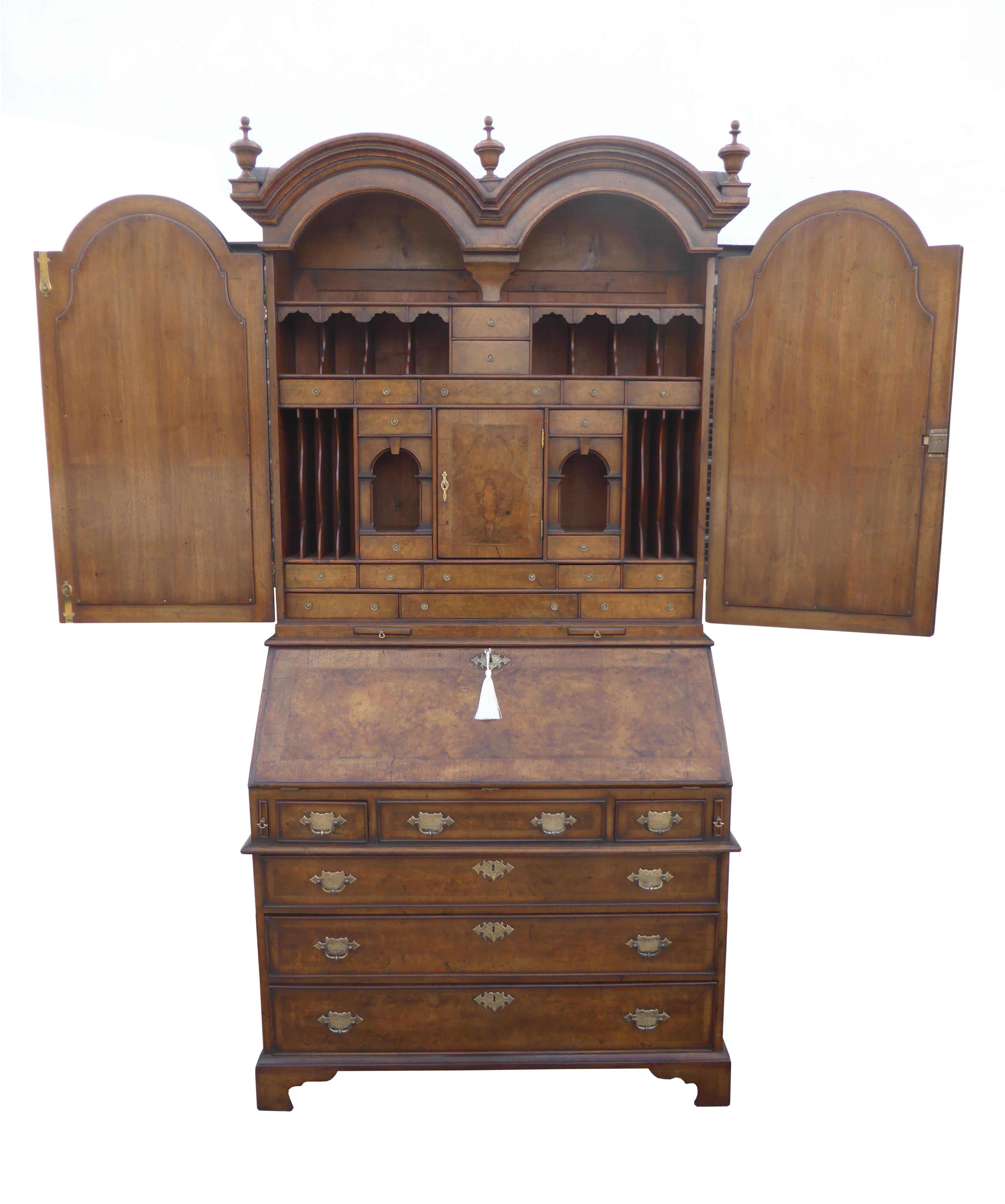 For sale is a very good quality burr walnut dome top bureau bookcase. The top of the bookcase has three finials with two glazed doors below. The doors open to reveal a superbly fitted interior which includes multiple drawers, pigeon holes and