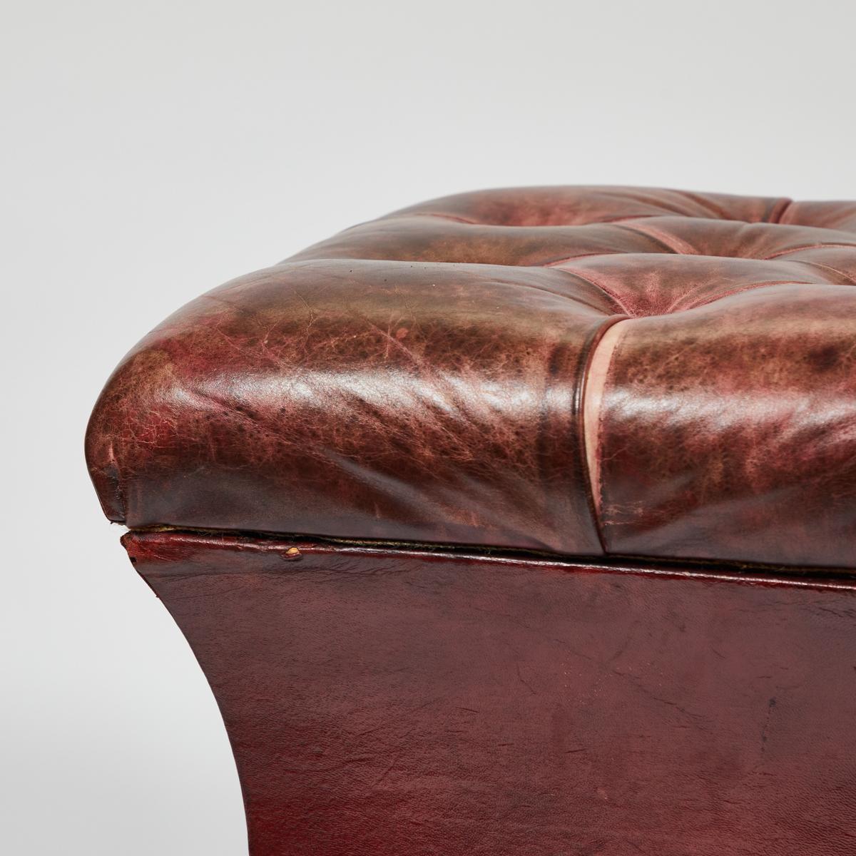 19th-century English tufted red leather ottoman with round disc feet and removable seat that lifts for storage. Handsome and discreet, this multifunctional piece has great lines and a rich, warm patina. 

England, circa 1890

Dimensions: 20W x 19D x