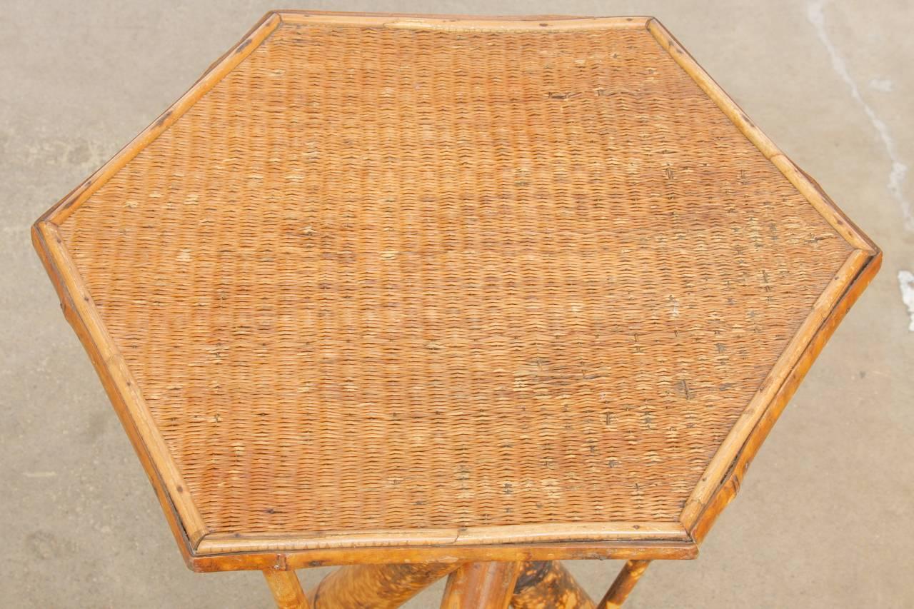 Interesting 19th century tortoise shell bamboo drinks table made in the regency style. Constructed with large bamboo in a tripod form supporting an octagonal top covered with raffia. The legs are conjoined with stretchers and thinner supports.