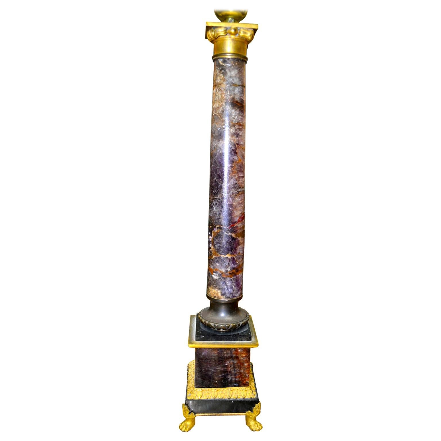 A very rare early 19th century English Regency Blue John stone, column lamp, having a gilt capital with a cut amethyst crystal finial. The column rests on a square blue john, and black marble base with a gilt bronze band and four gilt bronze paw